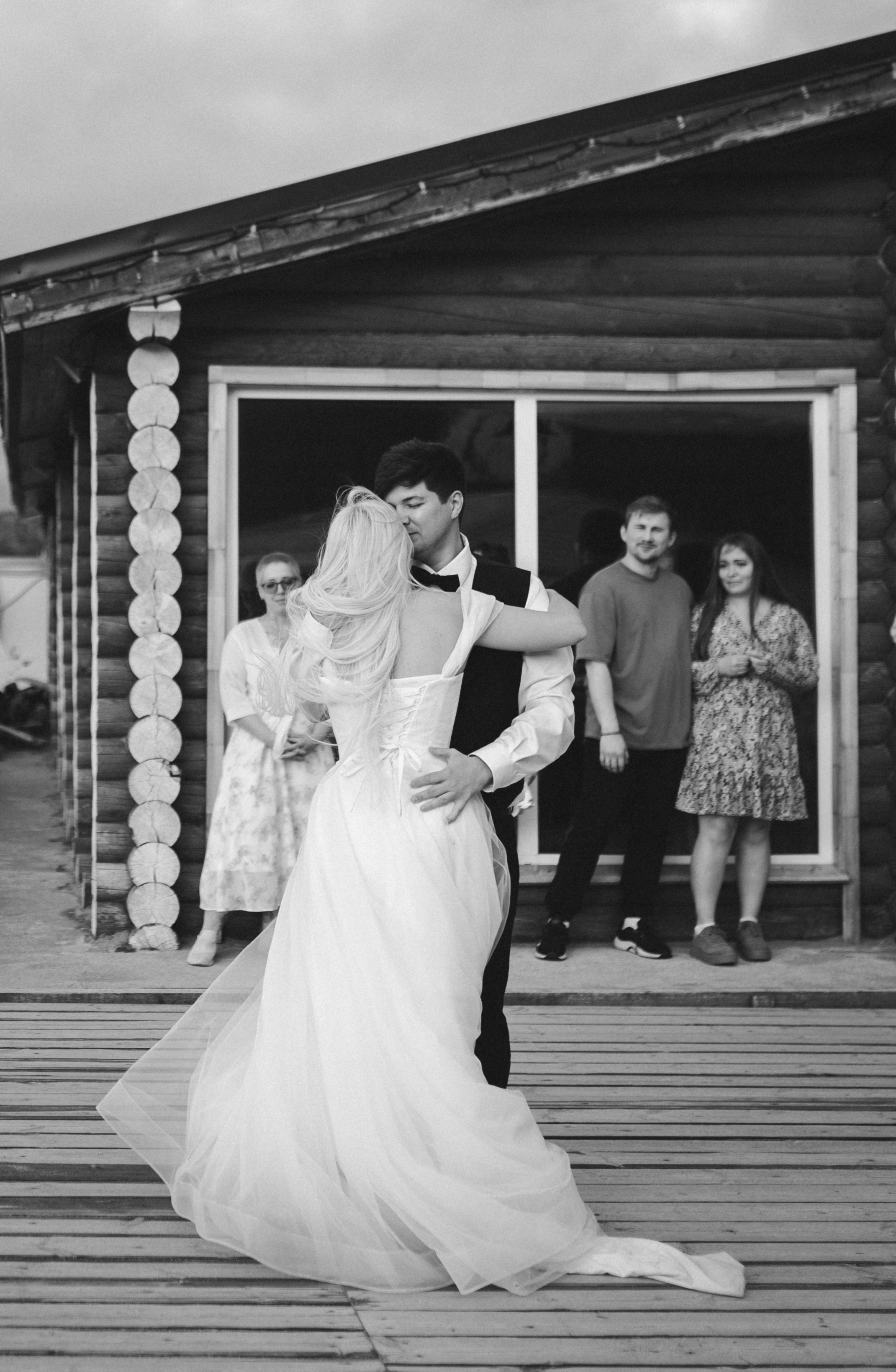 Закат солнца над Баренцевым морем и молодожёны, идущие рука об руку вдоль берега.