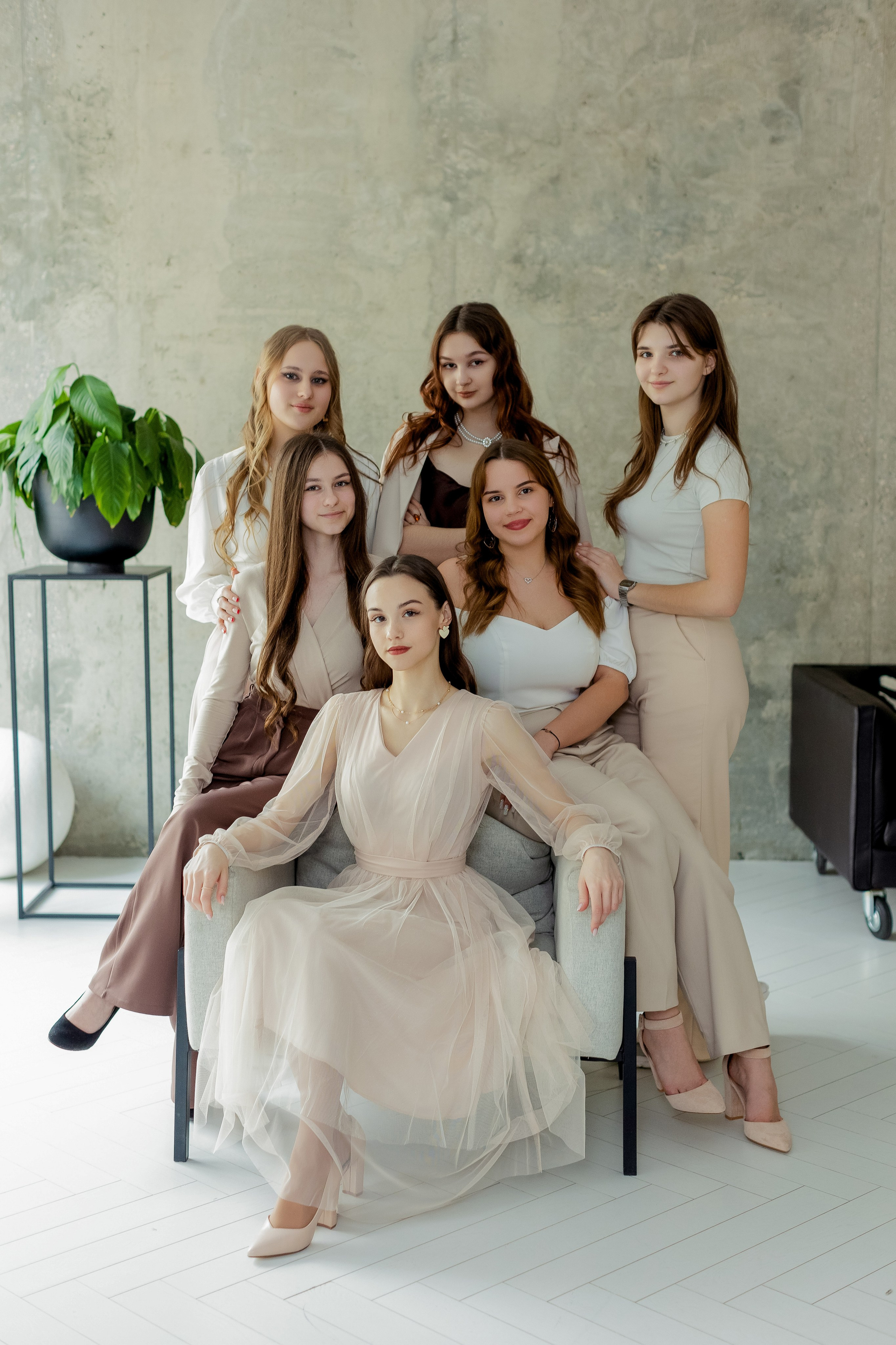Группа девушек сидит в кресле в фотостудии