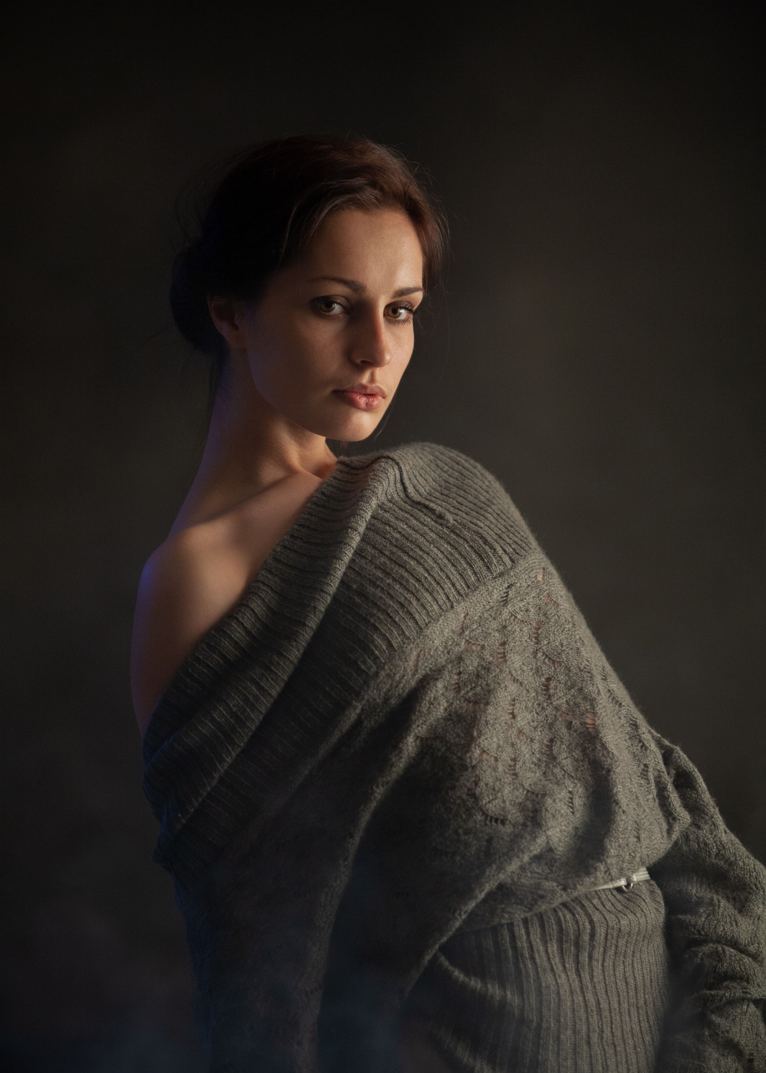 Молодая девушка позирует, прикрывая грудь грубой тканью