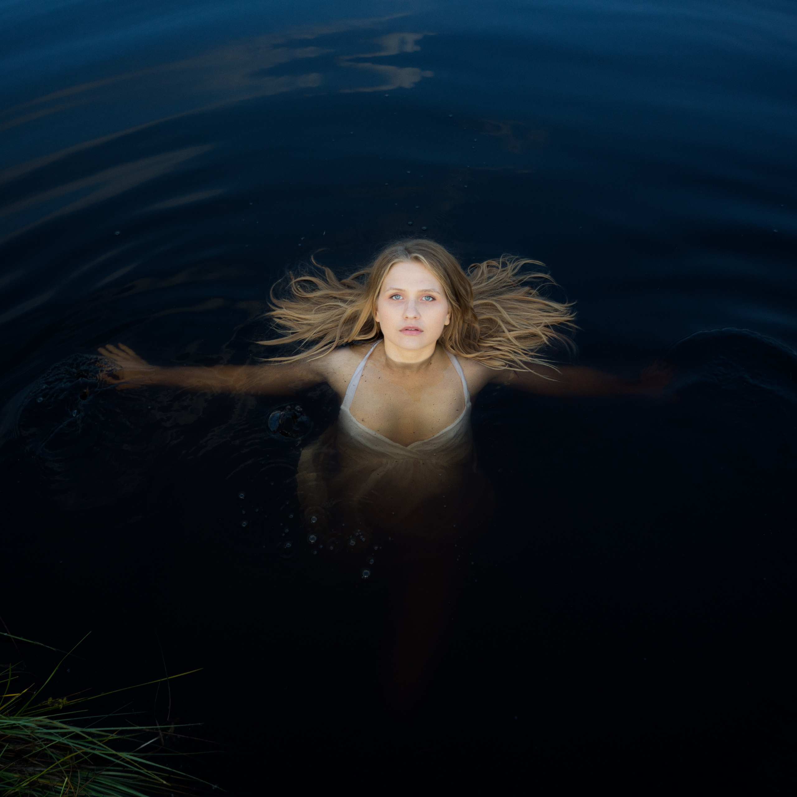 Молодая девушка находится в воде пруда