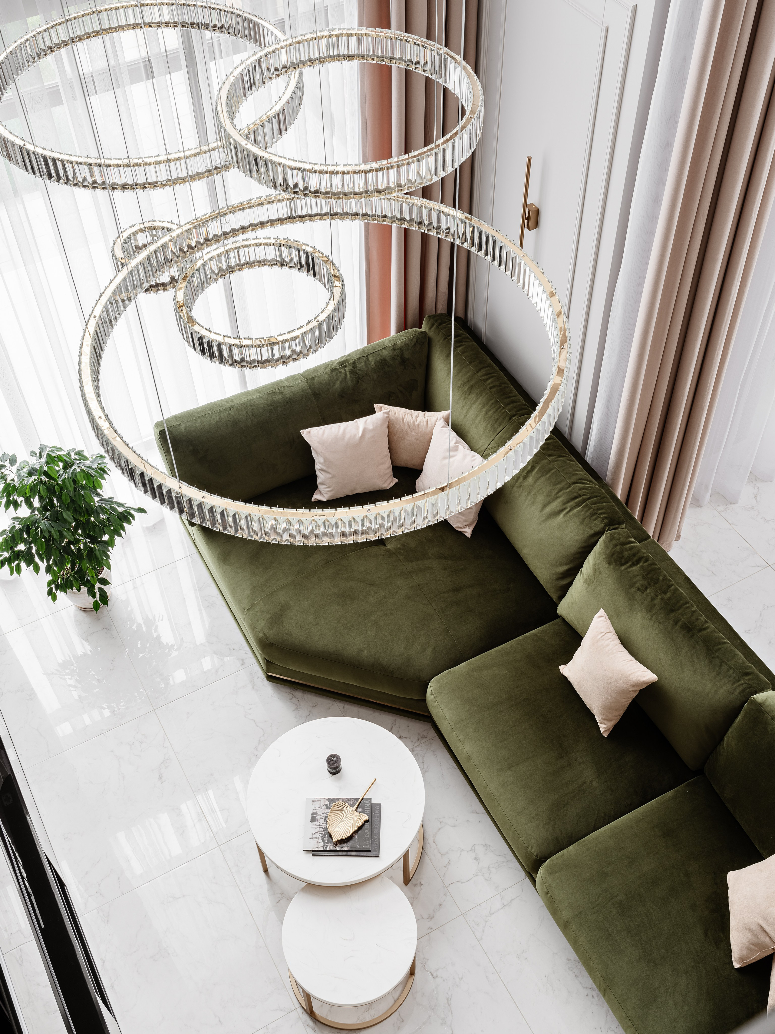 Вид сверху на гостиную с роскошной люстрой в виде стеклянных колец, зеленым диваном и мраморными столиками, гармоничный интерьер от дизайнера Евгении Ермошиной, фотограф Сергей Денисенко, современный стиль.