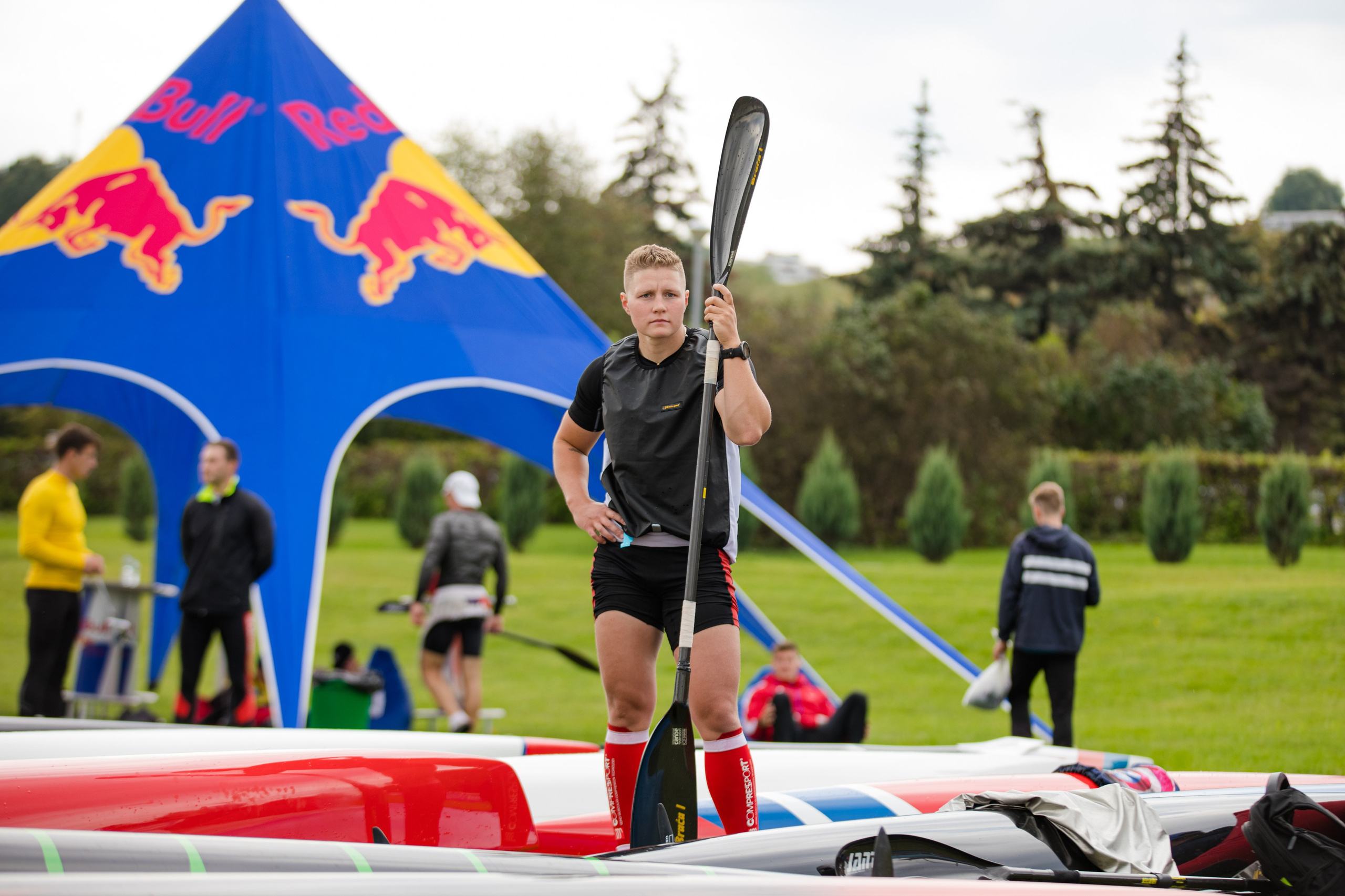 Девушка гребец держит в руках весло от лодки и смотрит вдаль