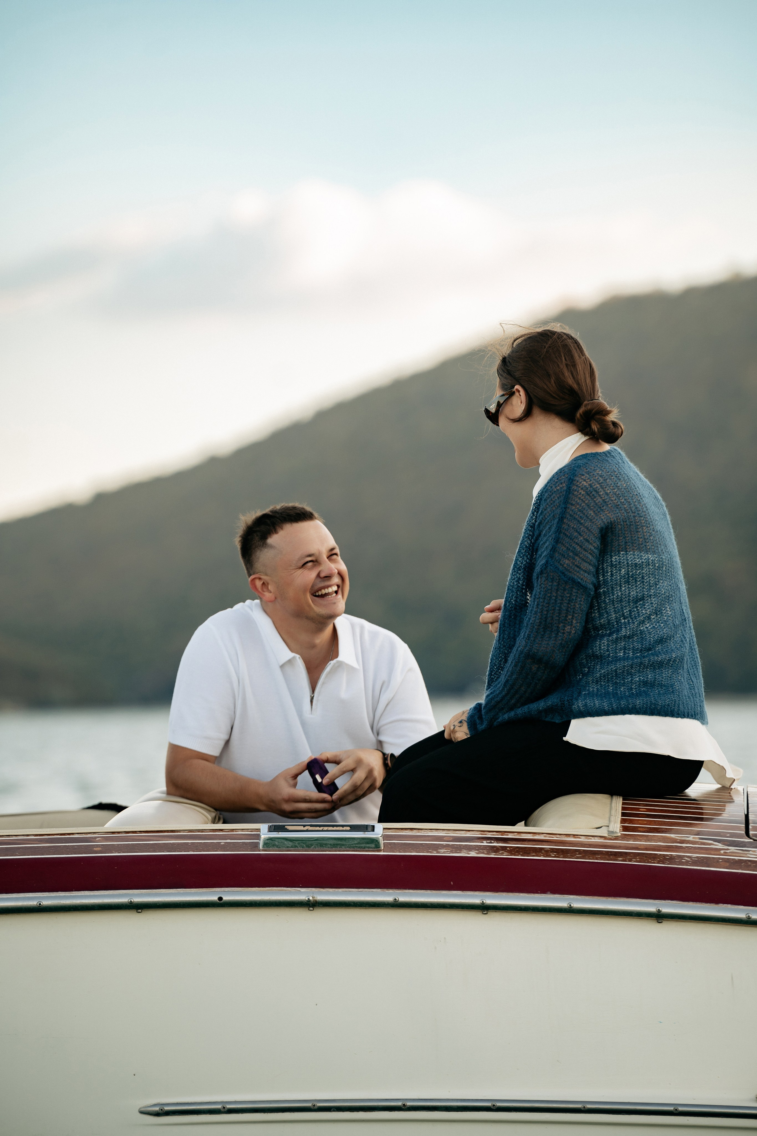 Шокированная реакция на предложение. Девушка только что услышала вопрос, ее глаза широко раскрыты от неожиданности, руки поднесены к губам. Эмоциональный и живой кадр.