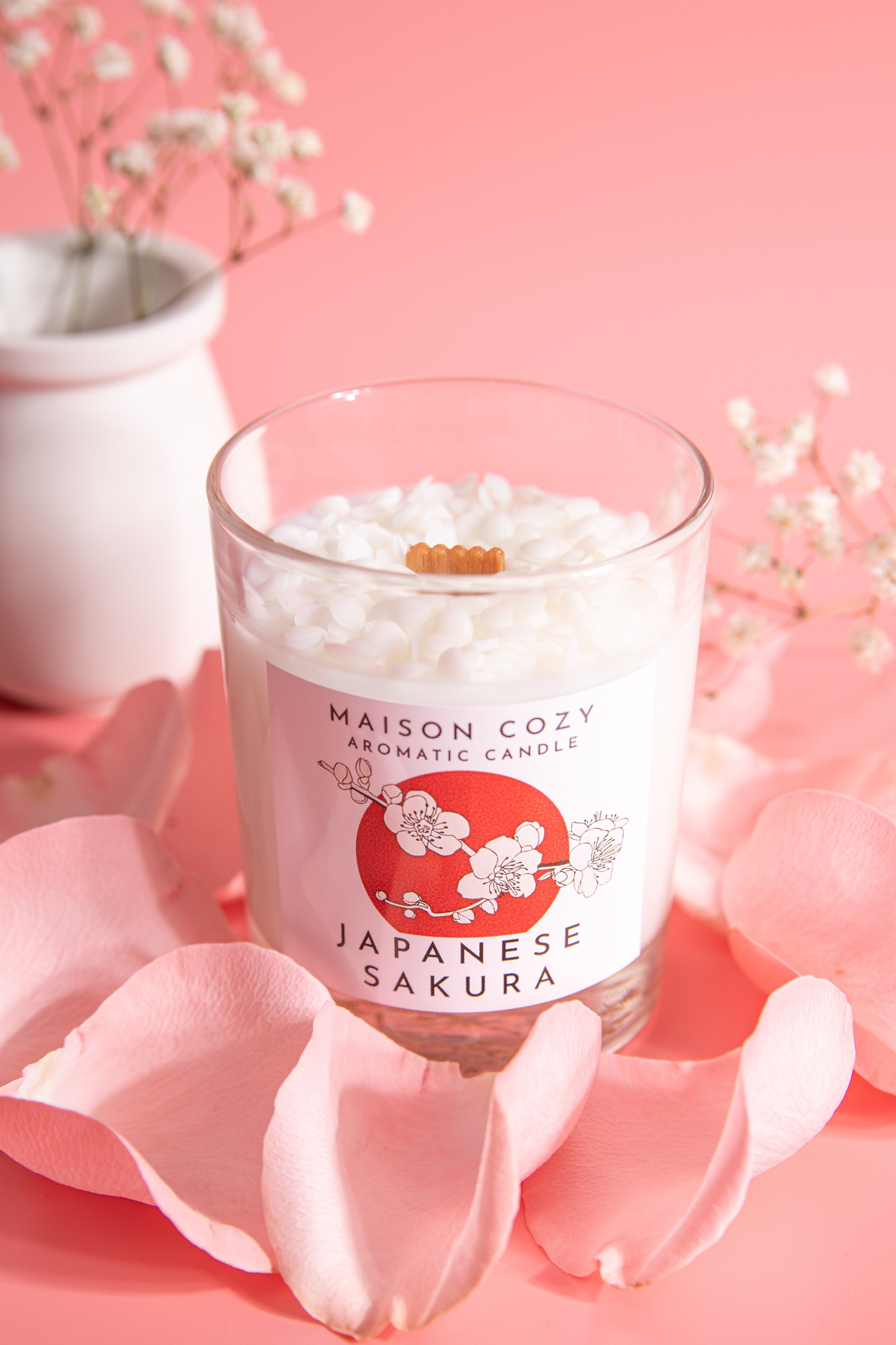 Ароматическая свеча с запахом цветущей сакуры в прозрачном стеклянном стакане, украшенном лепестками роз. Нежный розовый фон подчеркивает весеннюю эстетику. Натуральный соевый воск, деревянный фитиль и утонченный аромат японской вишни создают атмосферу гармонии и романтики. Идеально для медитации, оформления интерьера или в качестве элегантного подарка.
