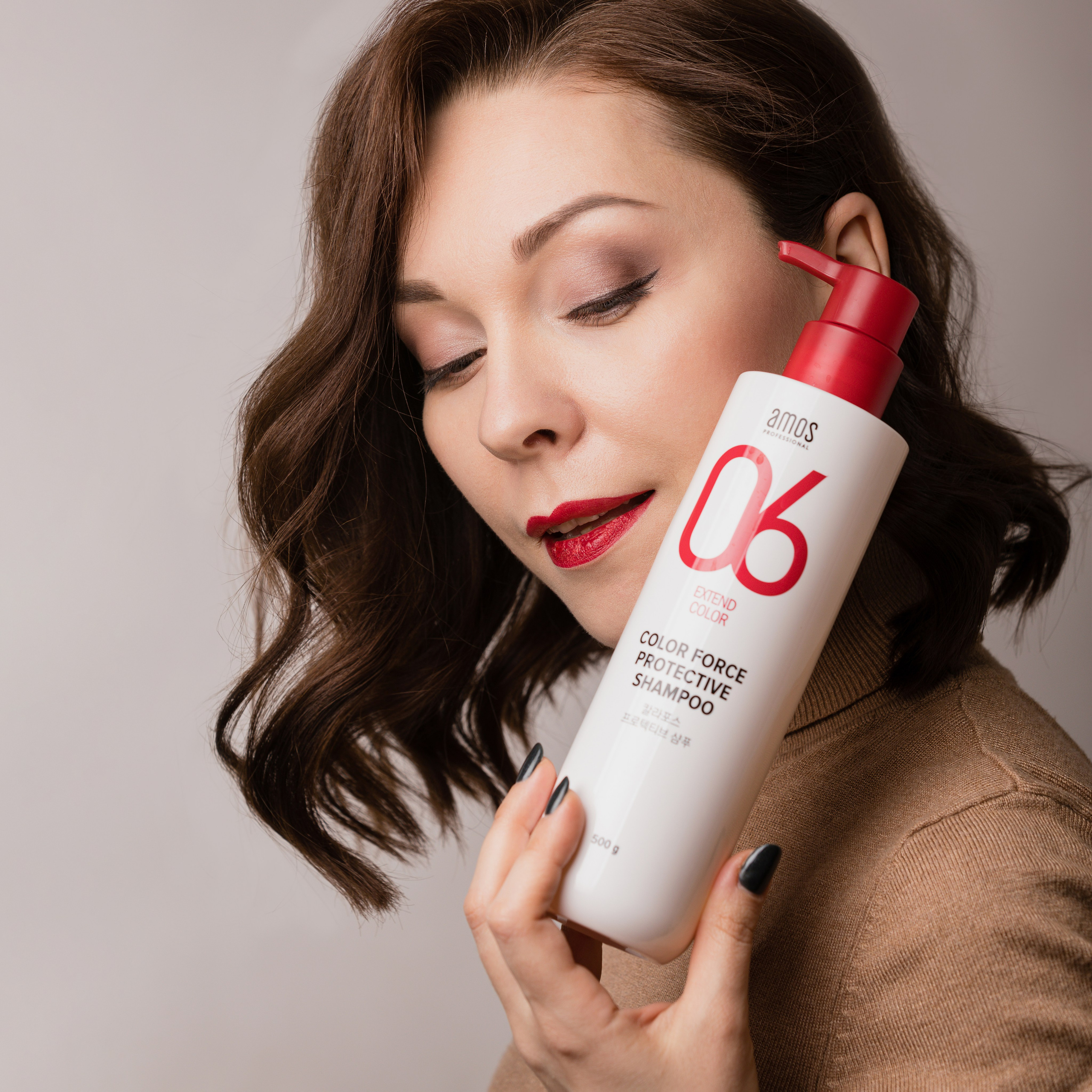 Девушка смотрит на флакон шампуня который держит в руке