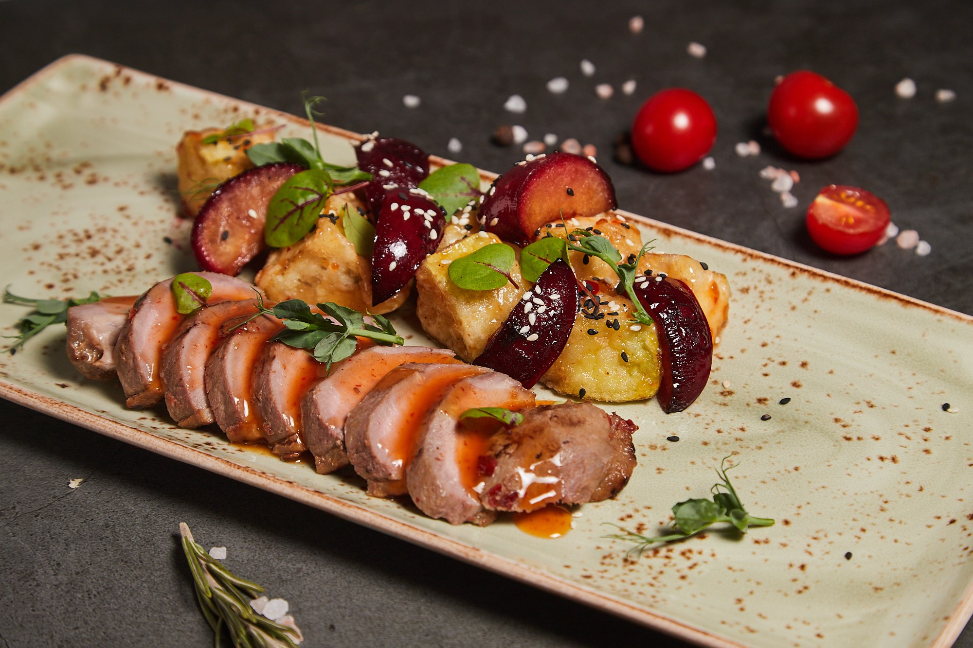 Фуд-фотография шашлычков из мяса и овощей на длинной тарелке.