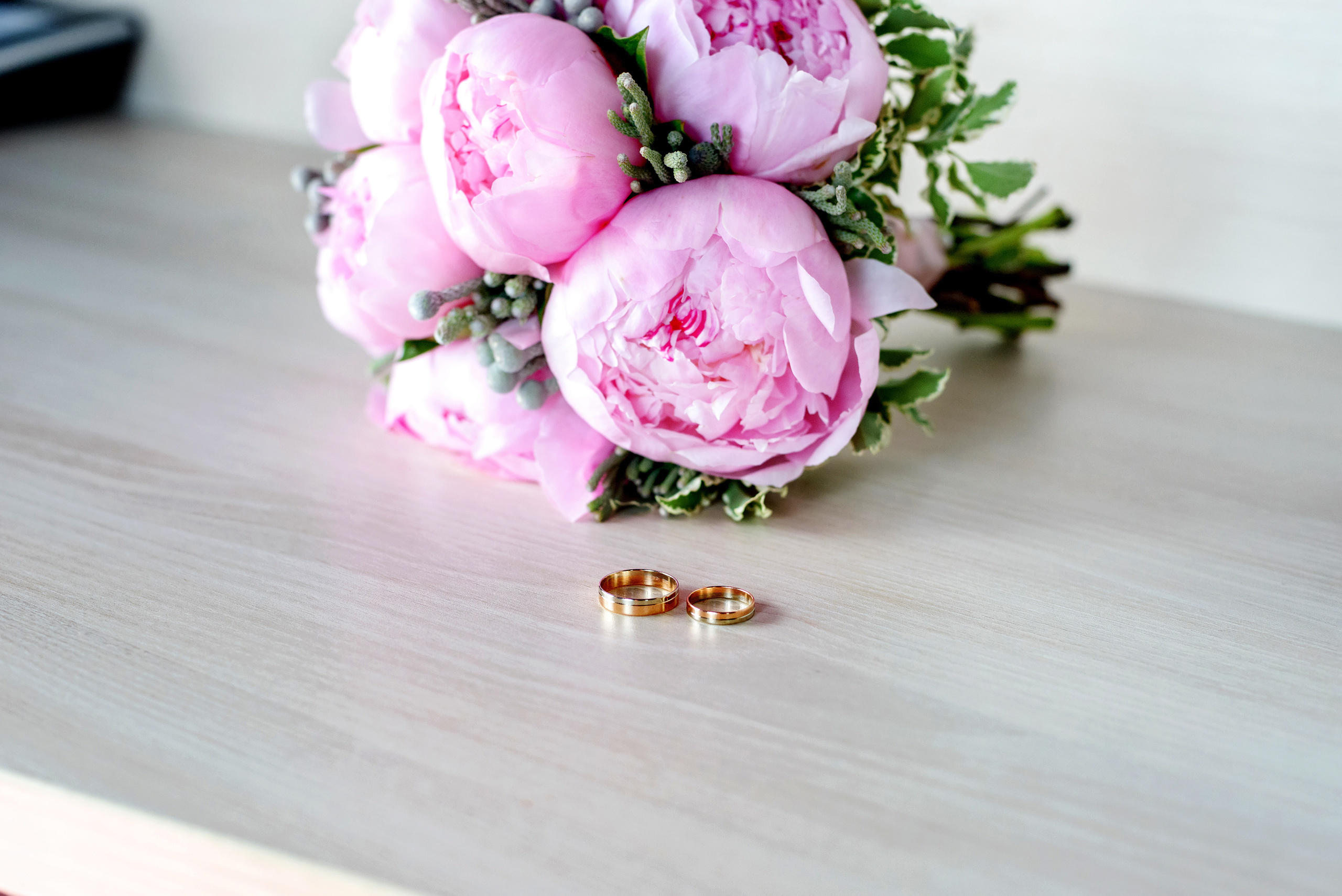 Кольца на фоне свадебного букета