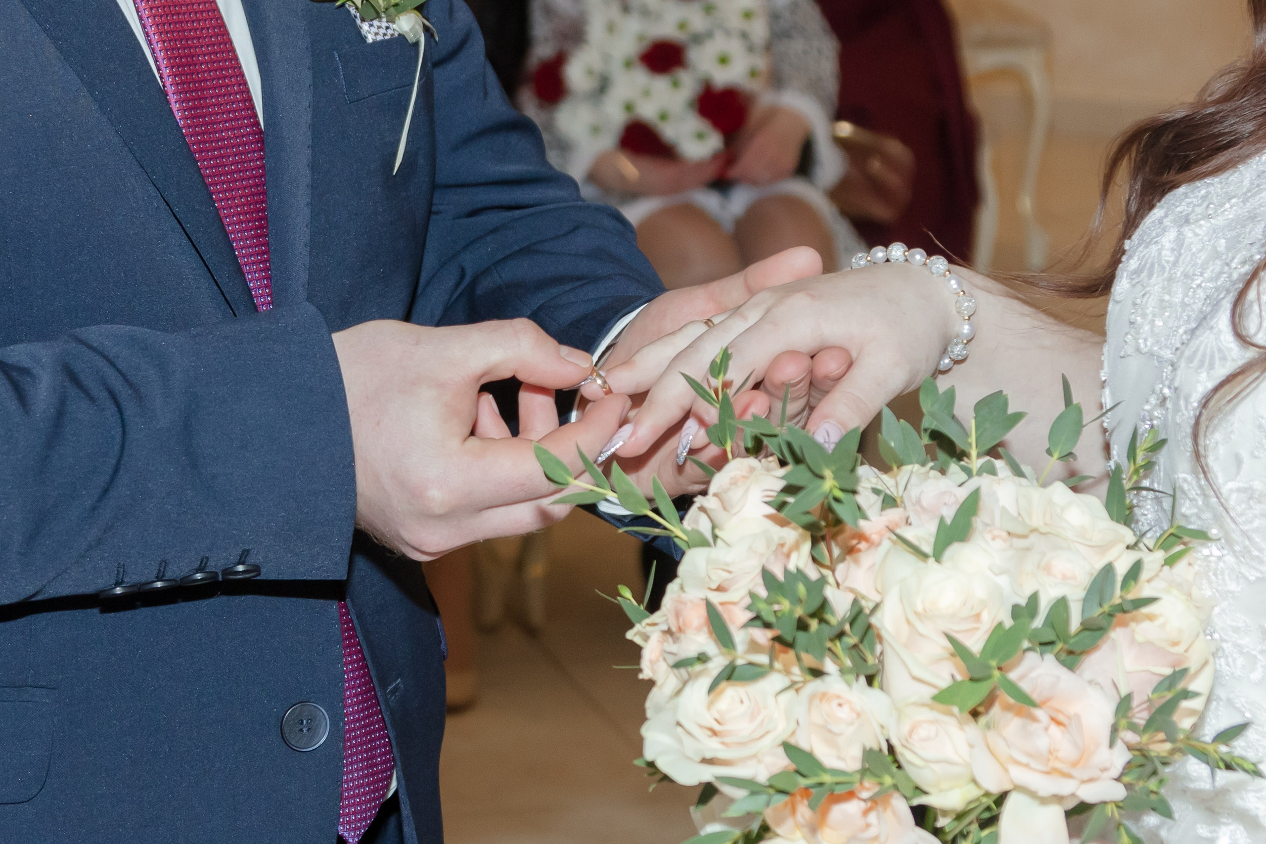 Жених надевает кольцо на палец невесте