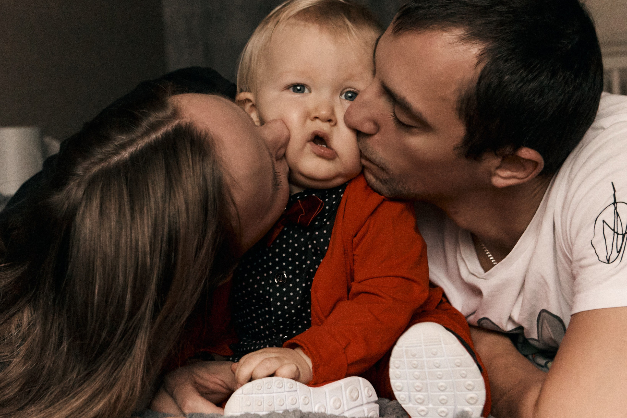 семейная фотосессия дома, родители целуют сына