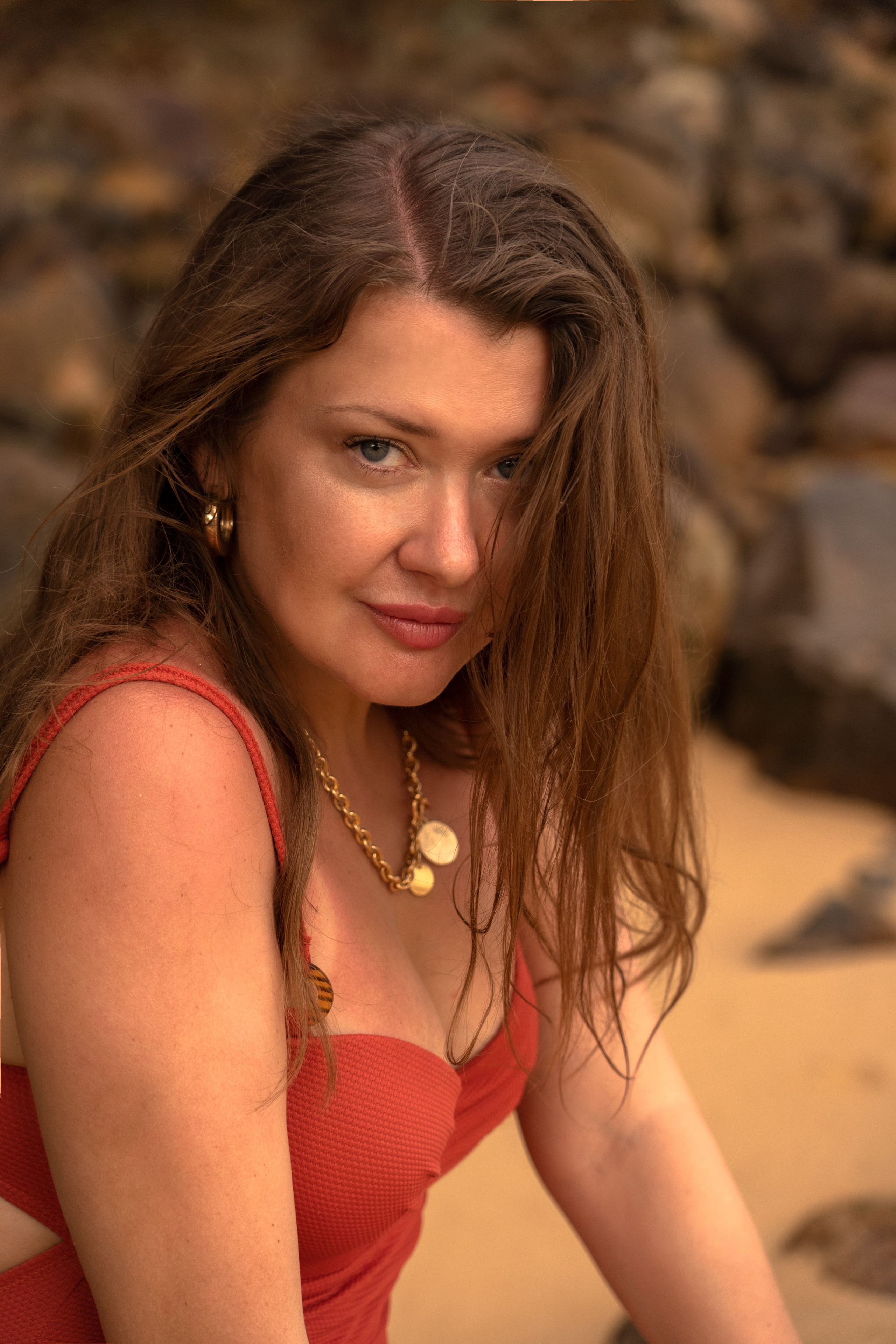 photoshoot of a girl in a red swimsuit on rocks by the water