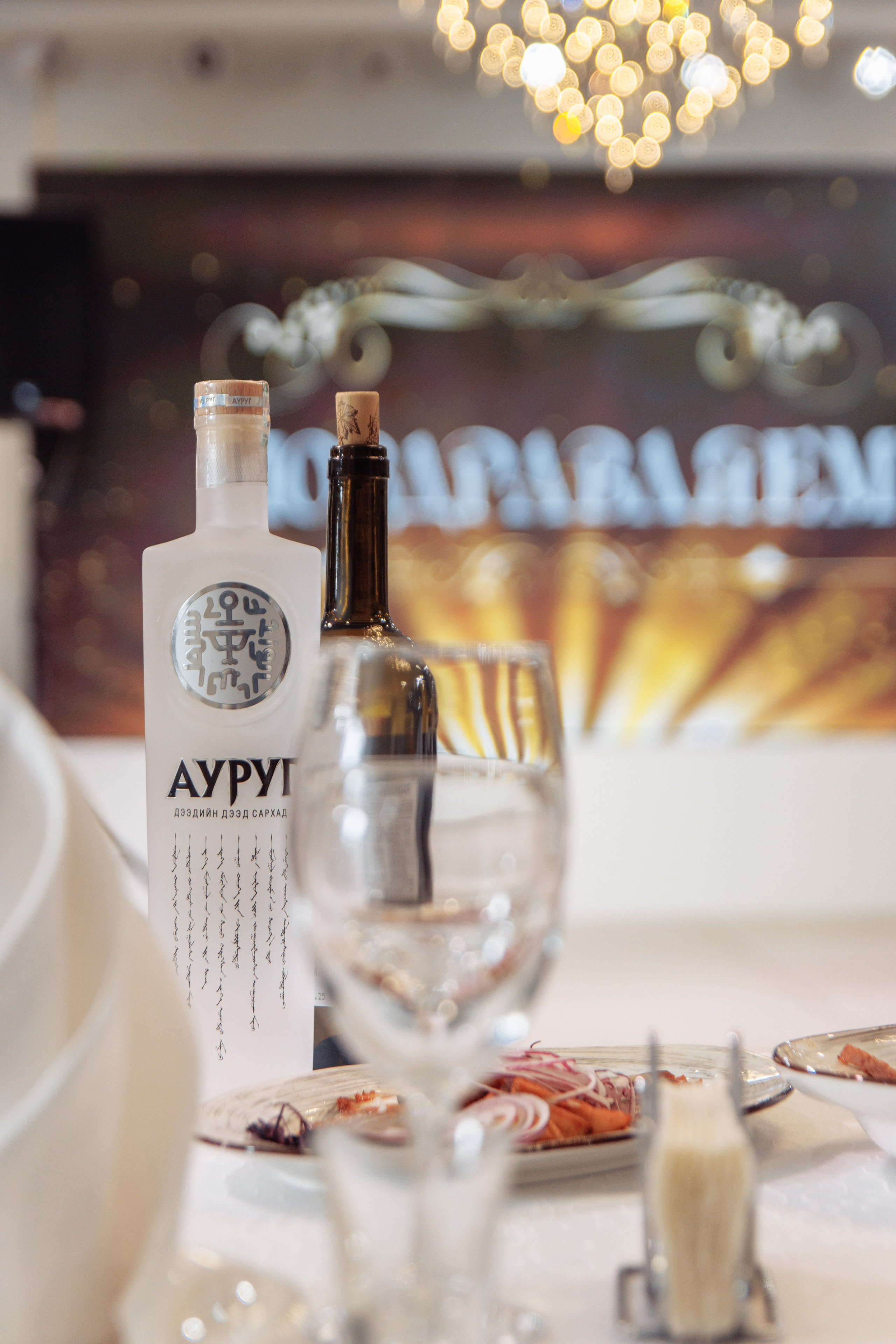 Фужеры и бутылка на столе с надписью «Архи»  