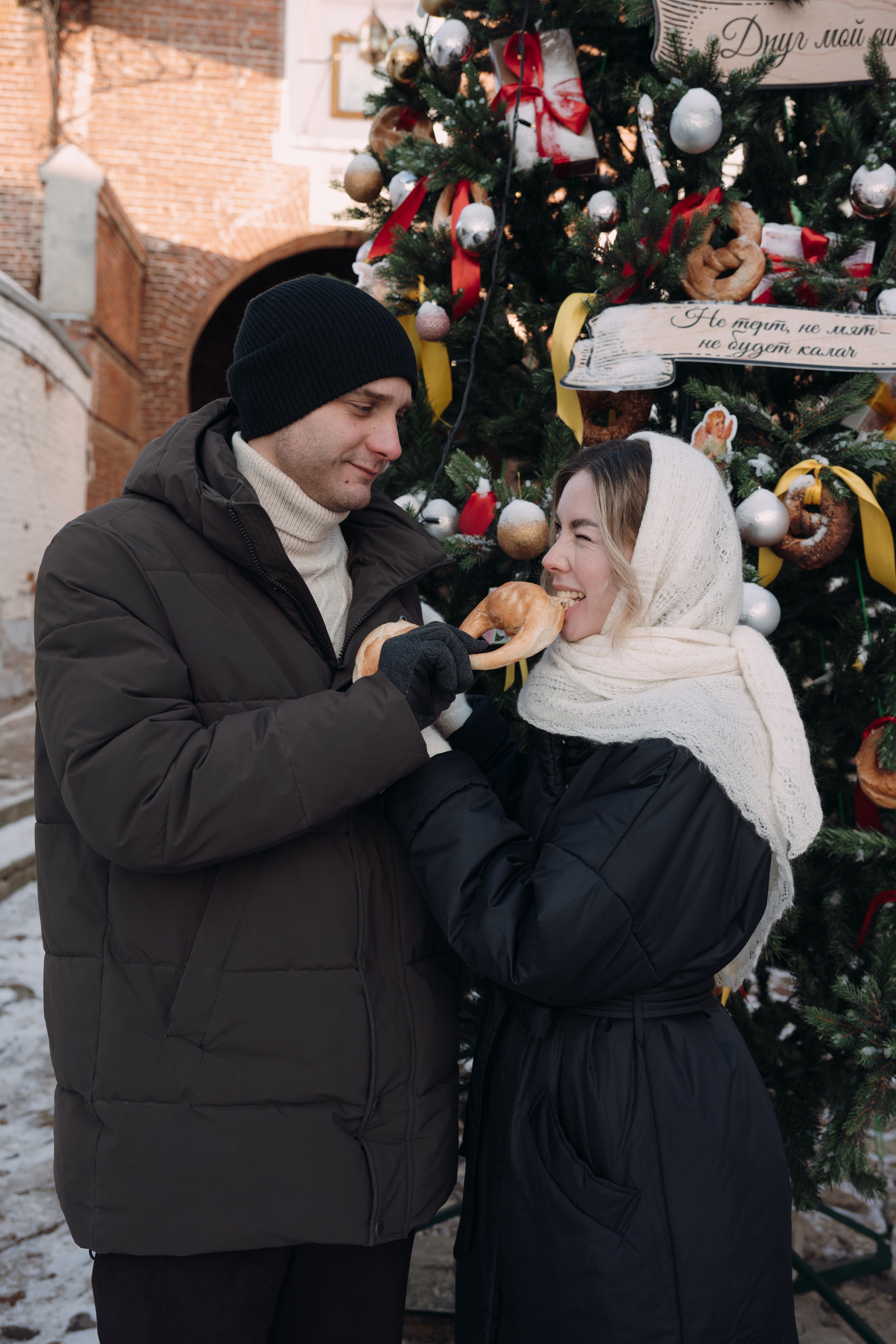 девушка и парень едят калач зимой на улице