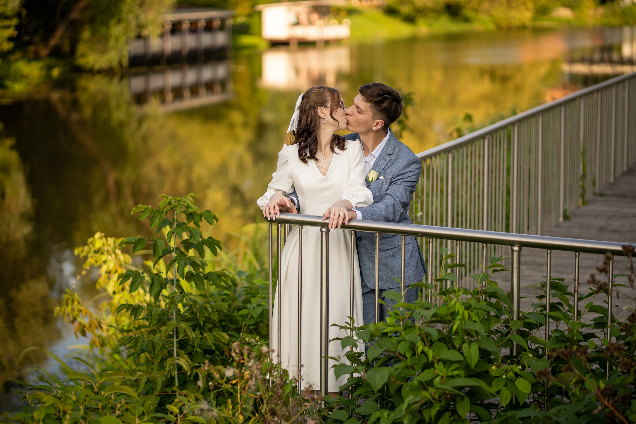  Молодожены целуются на мосту у реки