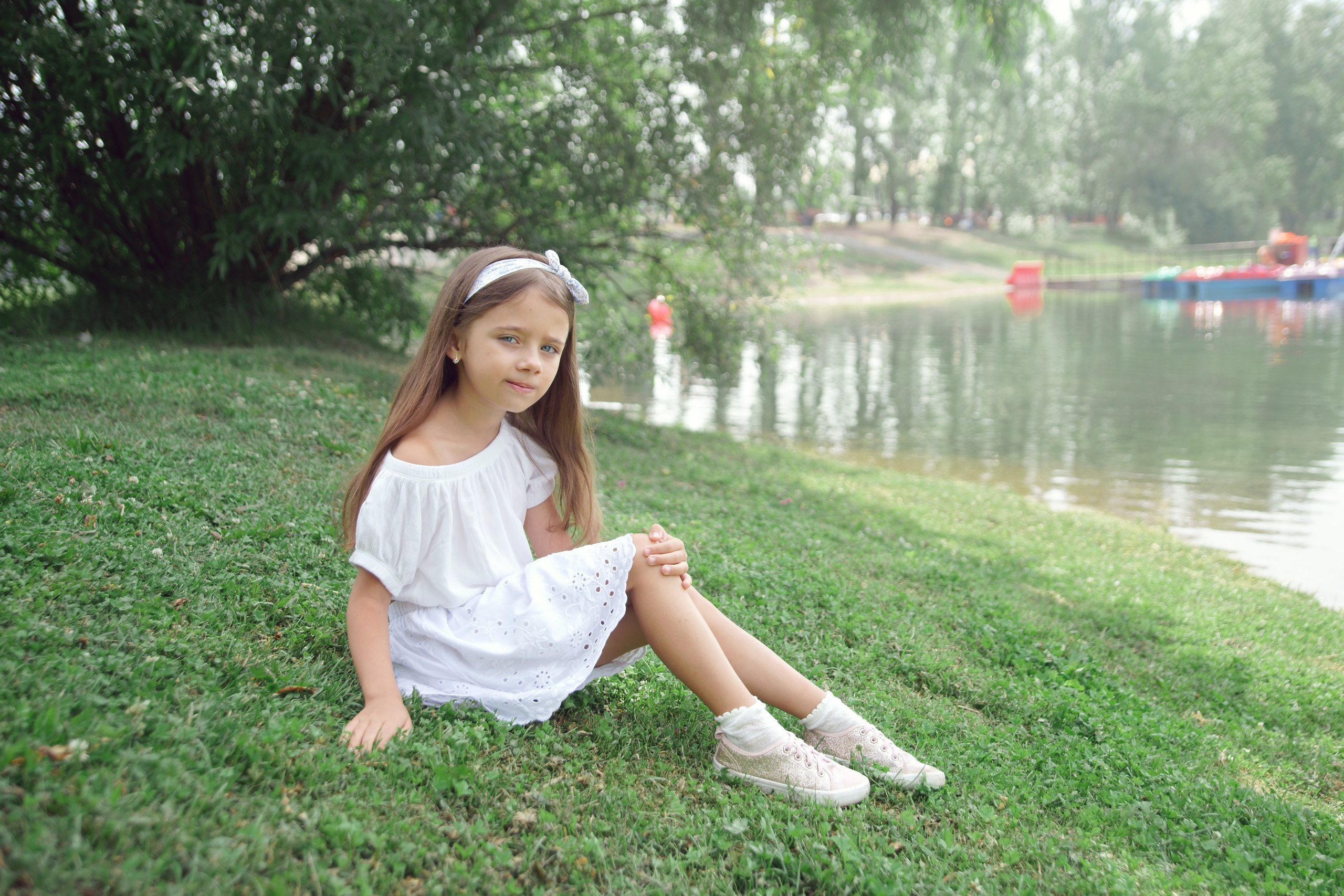 Детская фотосессия летом - девочка сидя на траве у реки