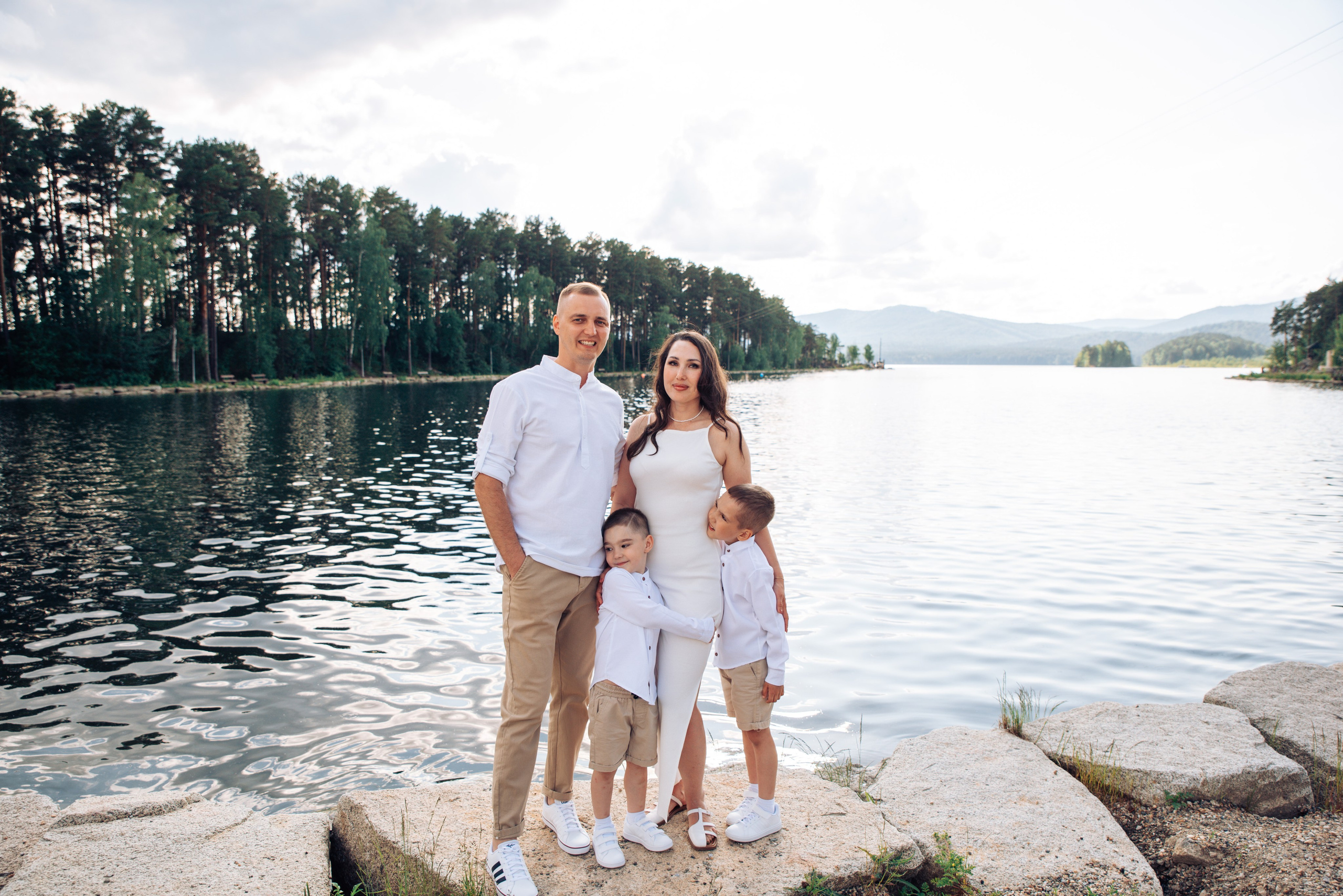 Семейная прогулка летом на берегу озера по пляжу