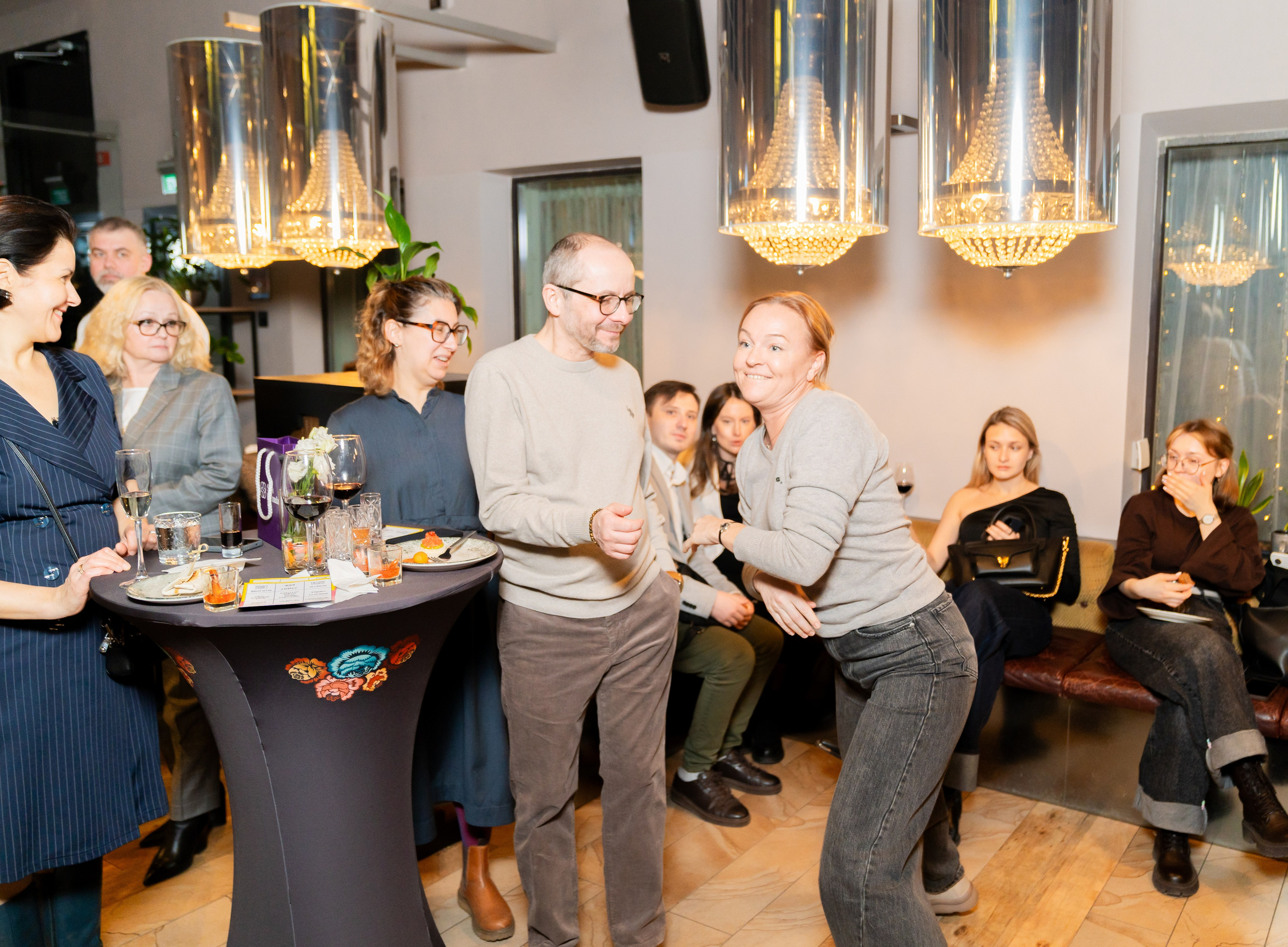 Весёлые гости на корпоративном мероприятии в Radisson Sonya. Женщина в сером свитере активно общается и смеётся. Фото Евгения Мальцева.