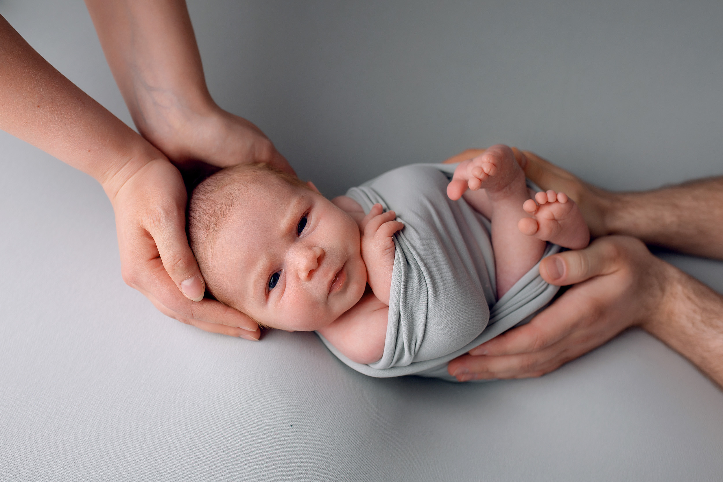 Фотосессия новорожденного с руками родителей в обмотке