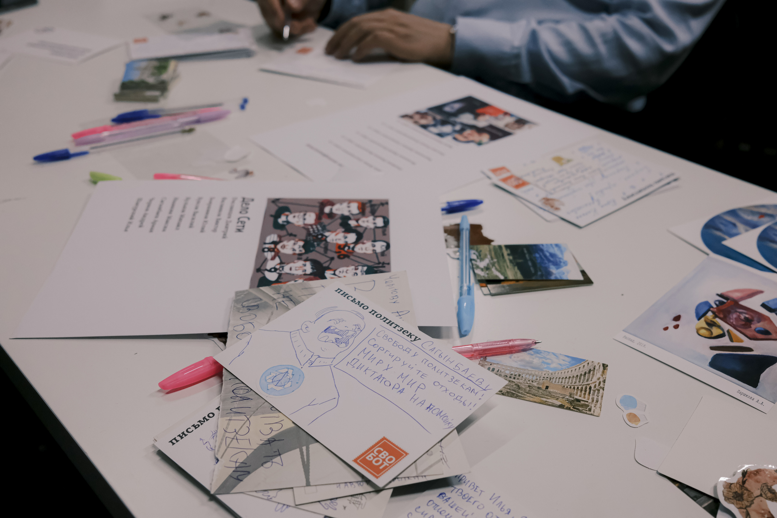 Signing postcards for political prisoners, September 2022. Photographer in Israel Alice Milchin