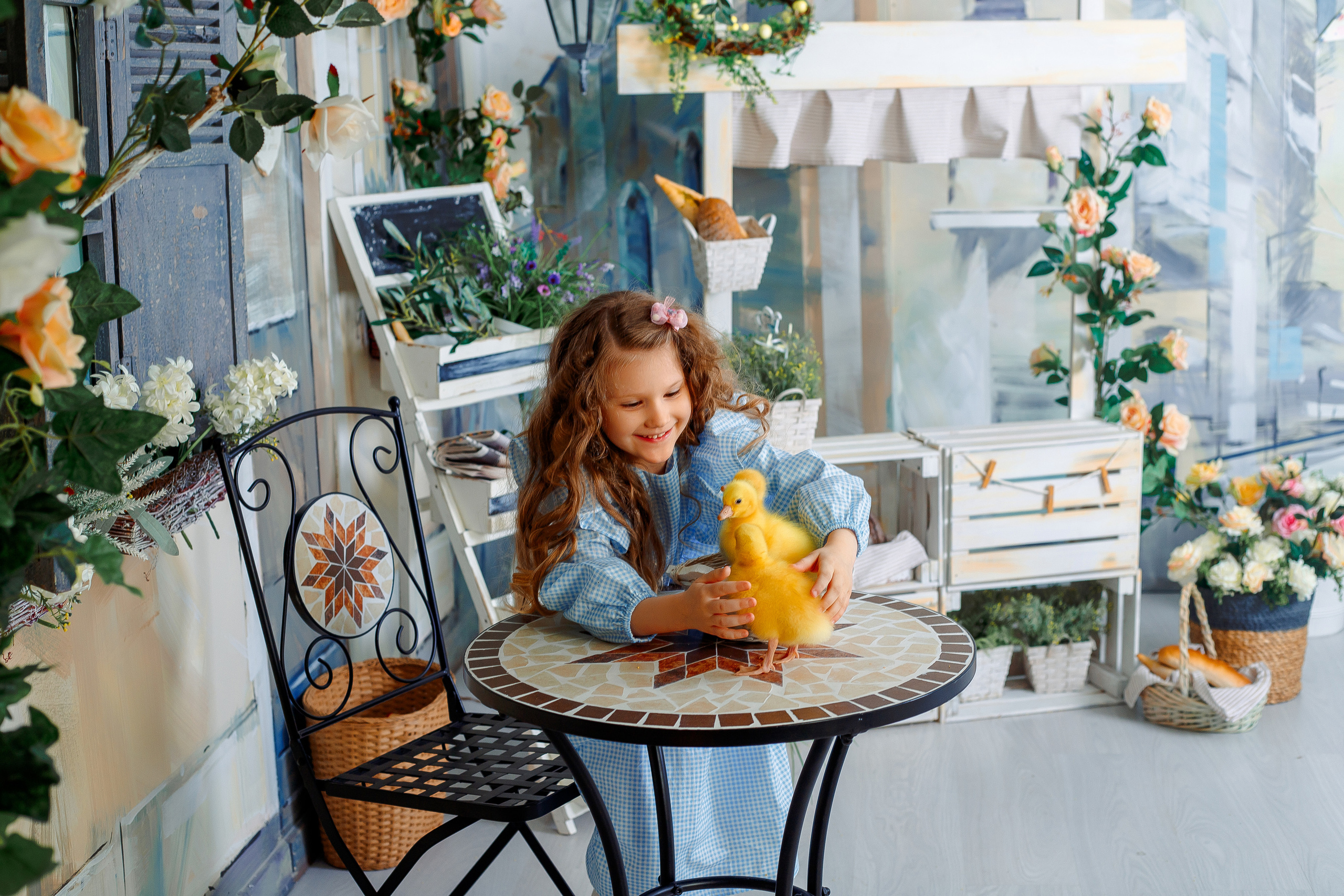 Девочка в голубом платье ставит утят на стол