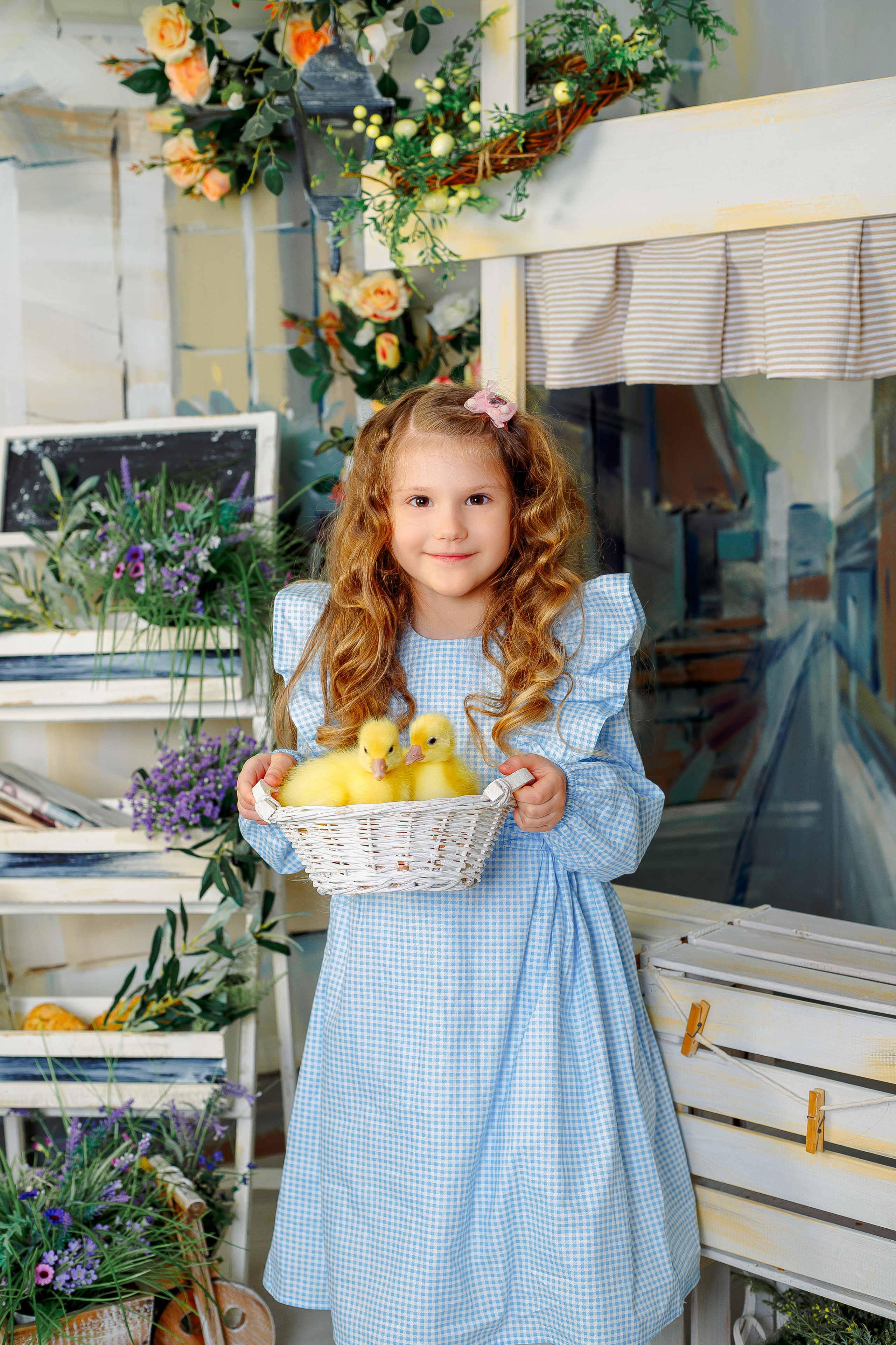 Девочка с голубом платье держит корзинку с утятами