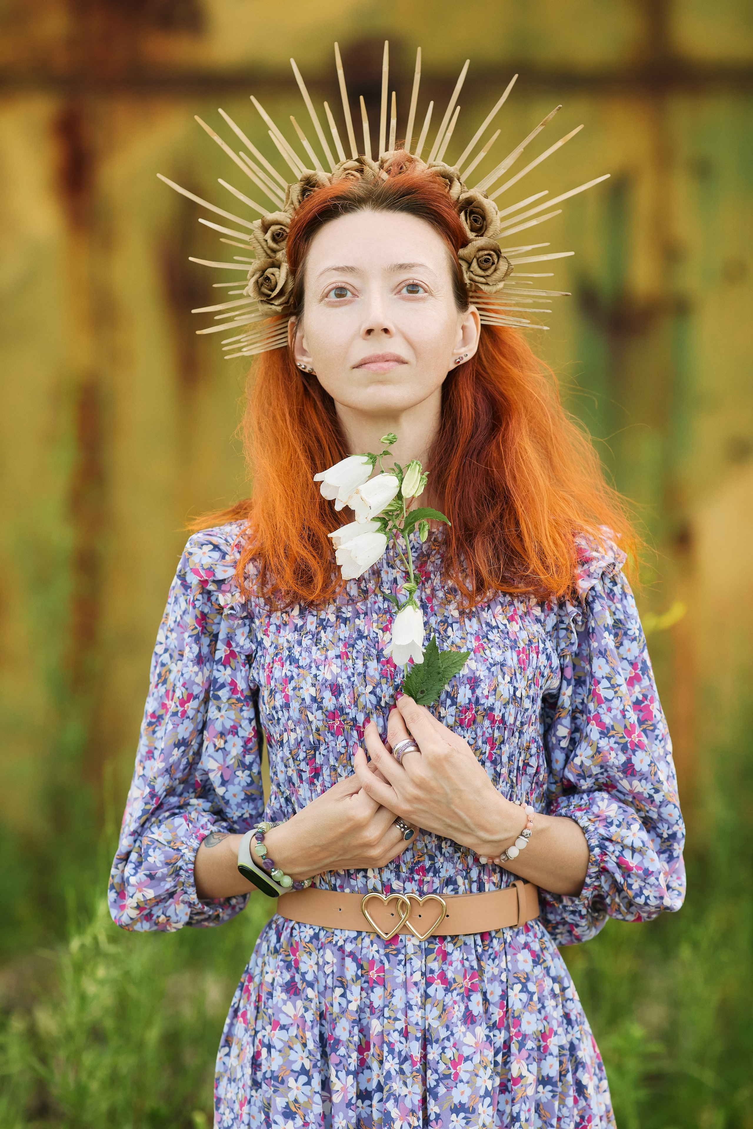 Фэнтези фотосессия с цветами и декоративным венком на голове на фоне заброшенного здания