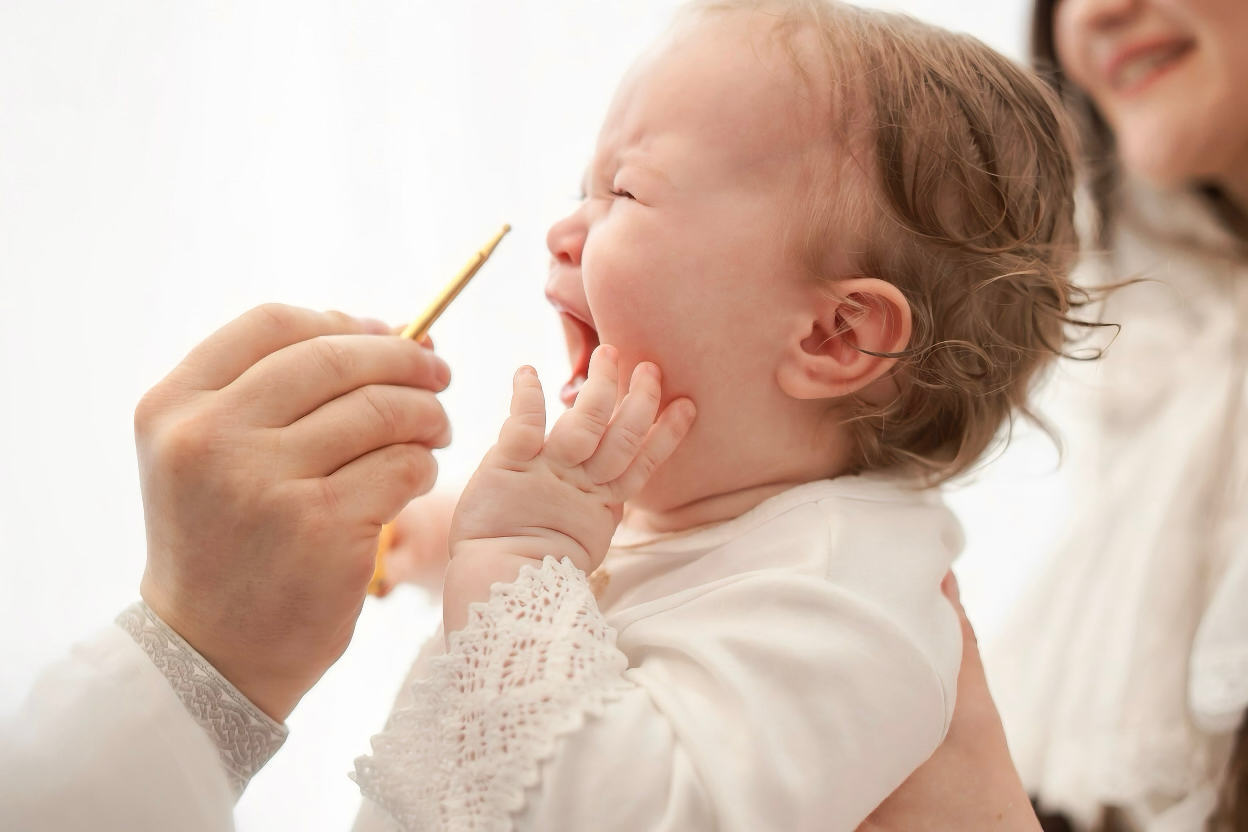 Миропомазание — золотая кисточка у щеки младенца, мягкий белый свет — Екатеринбург, Илья Антропов