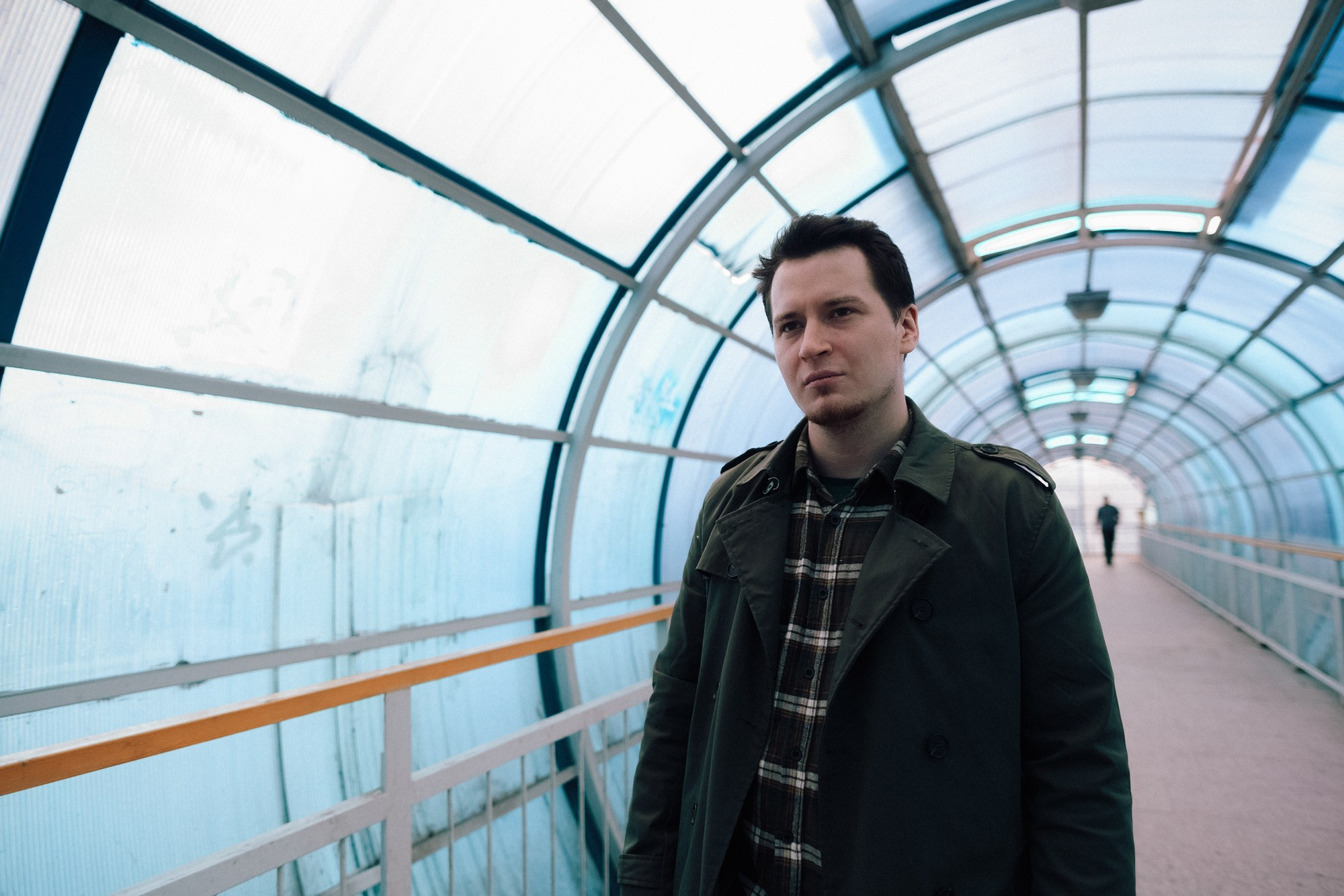 Мужчина в туннеле из железных конструкций, черно-белая фотография