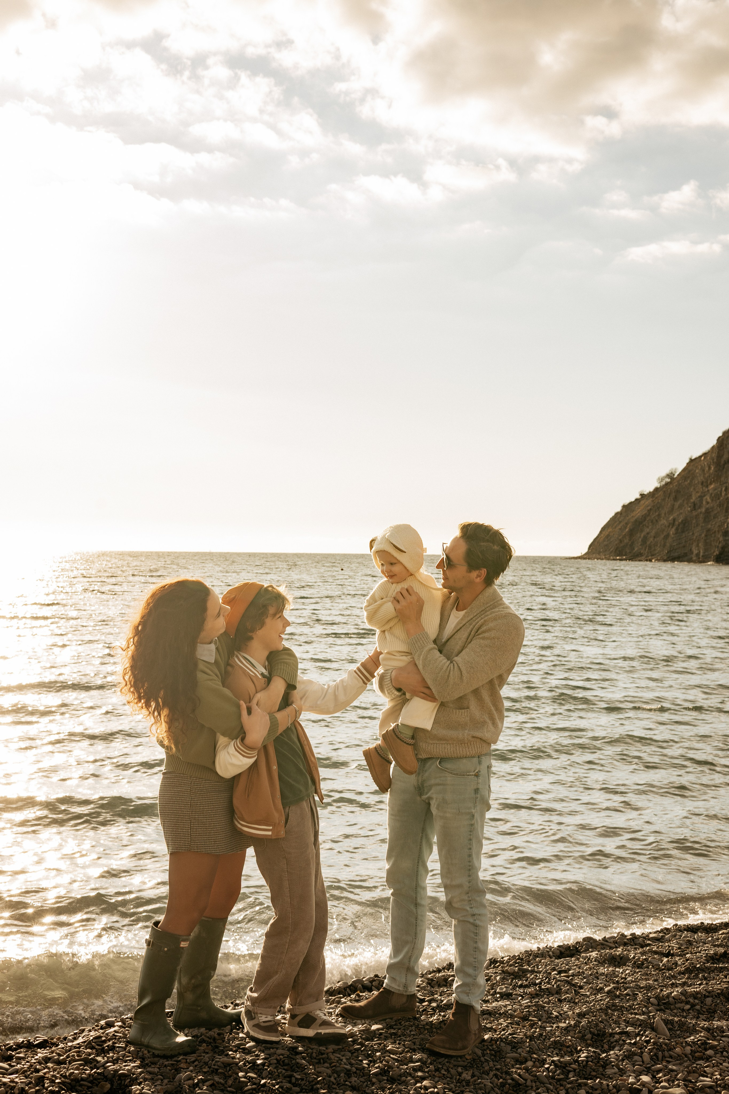 Счастливая семья из четырех человек на закате в Абрау-Дюрсо