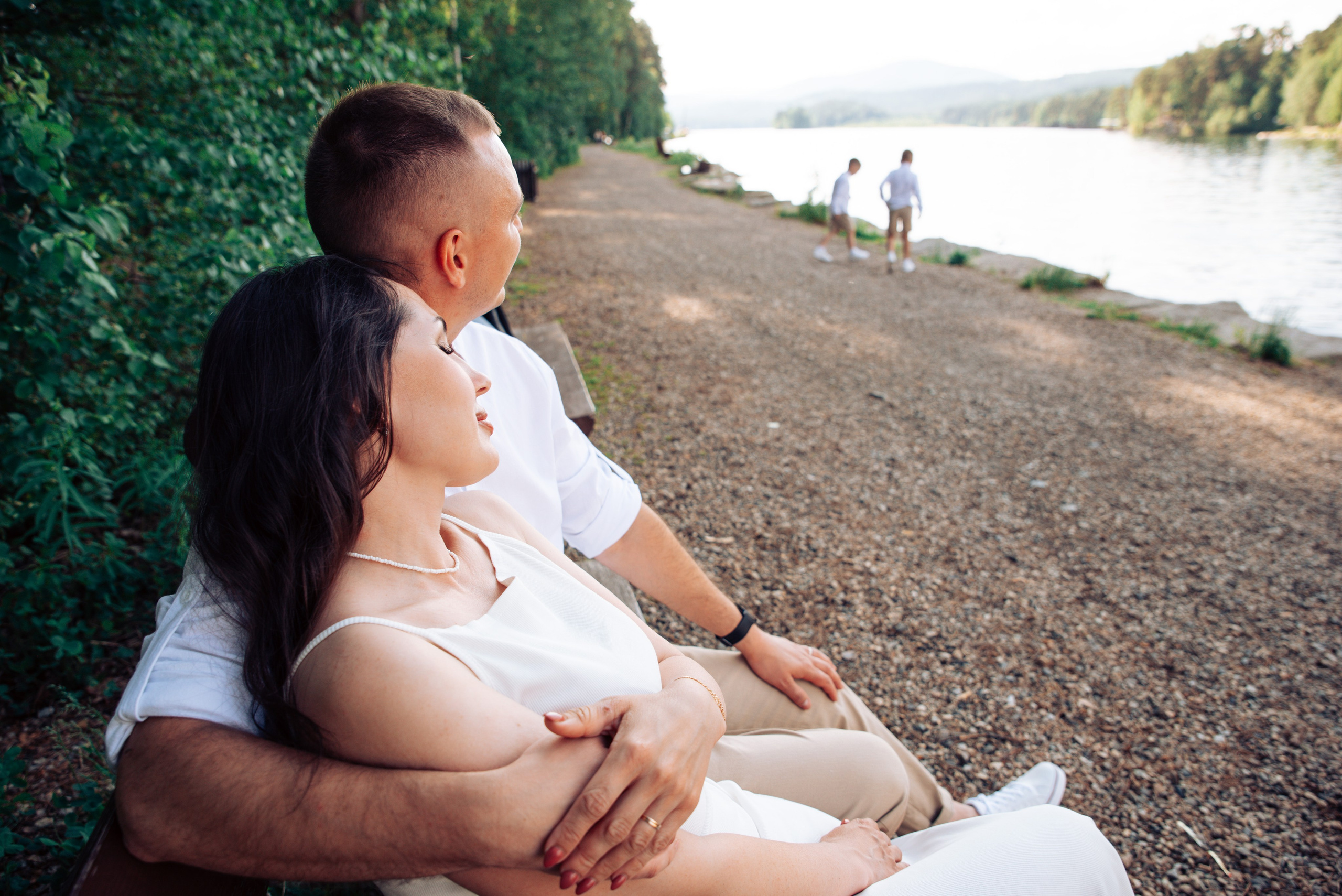 Семейная прогулка летом на берегу озера по пляжу