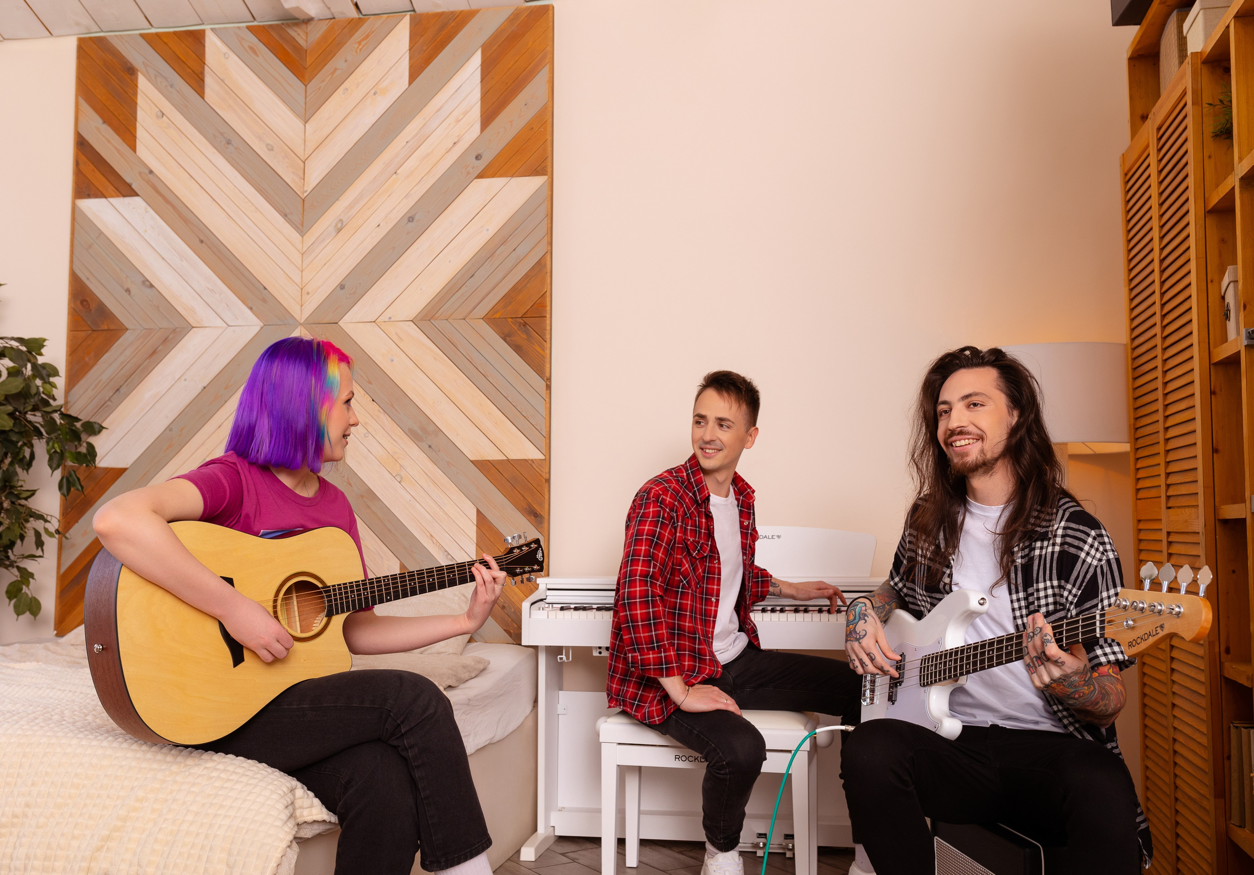 Три музыканта сидят за музыкальными инструментами.