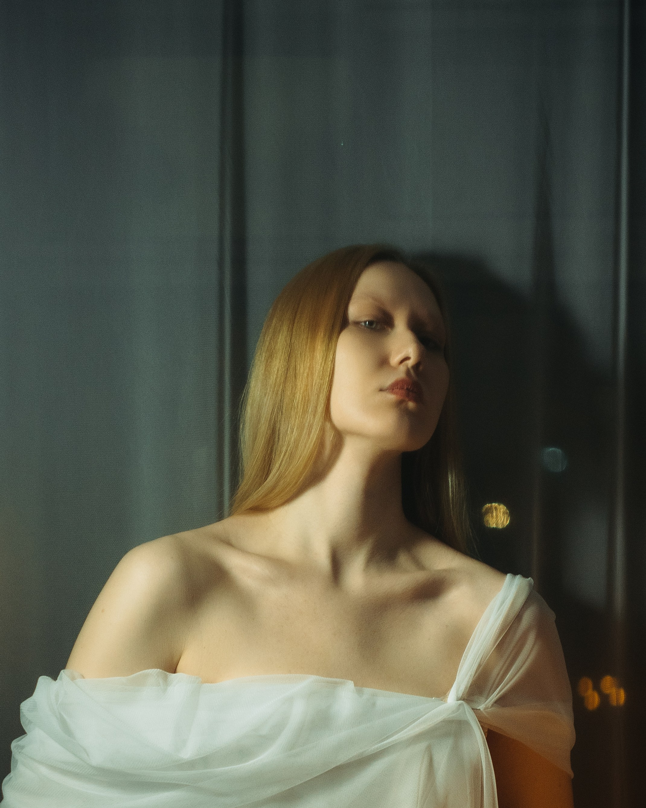 Крупный портрет девушки в отражении стекла, авторская фотосессия в студии с мягким светом и чувственной арт подачей
