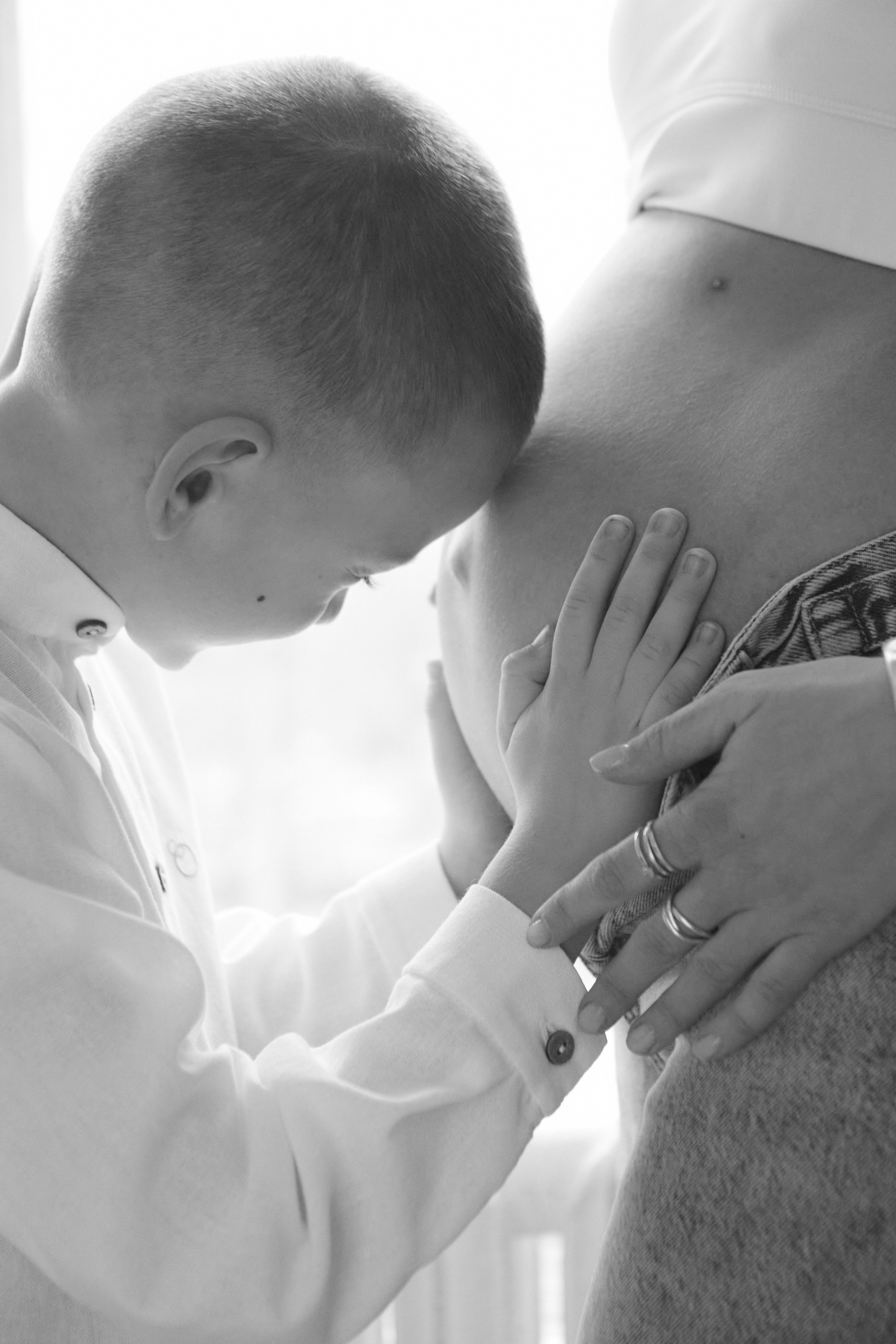 фотосессия беременности в Москве, фотосессия в студии, сын трогает живот беременной мамы, семейный фотограф в Москве