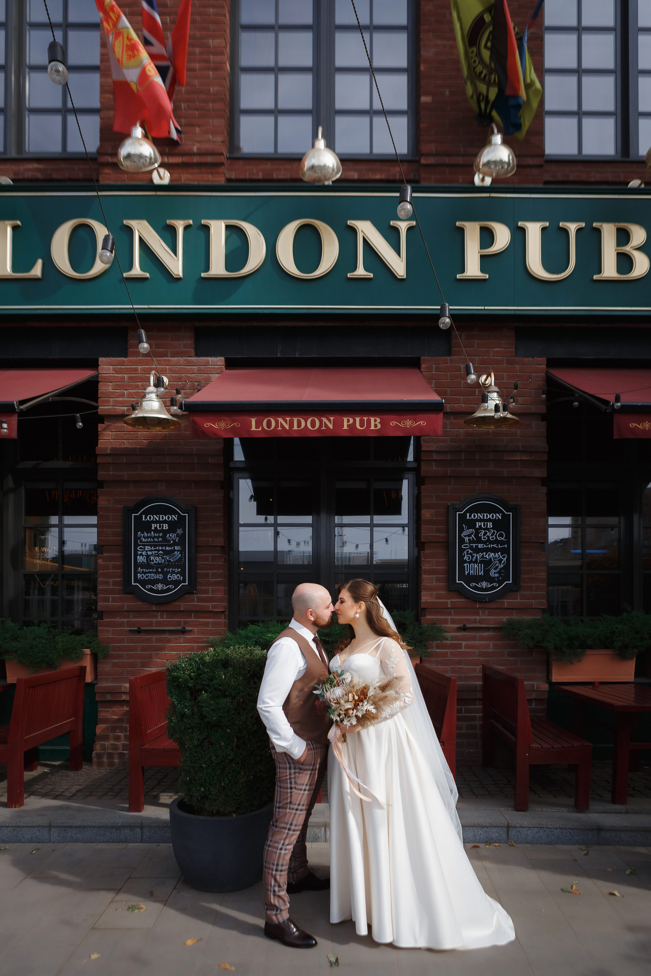 свадебные фотографии пары на фоне фасада London Pub