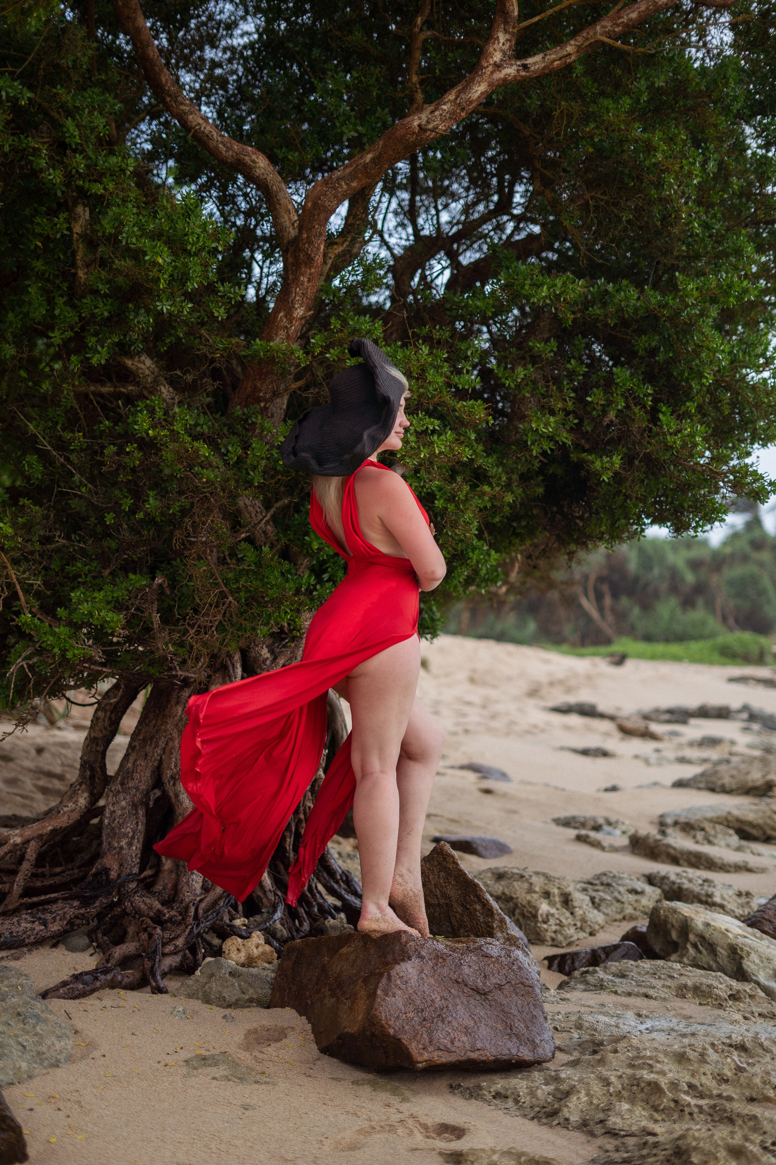 a beautiful blonde in a red dress against the backdrop of the vast ocean