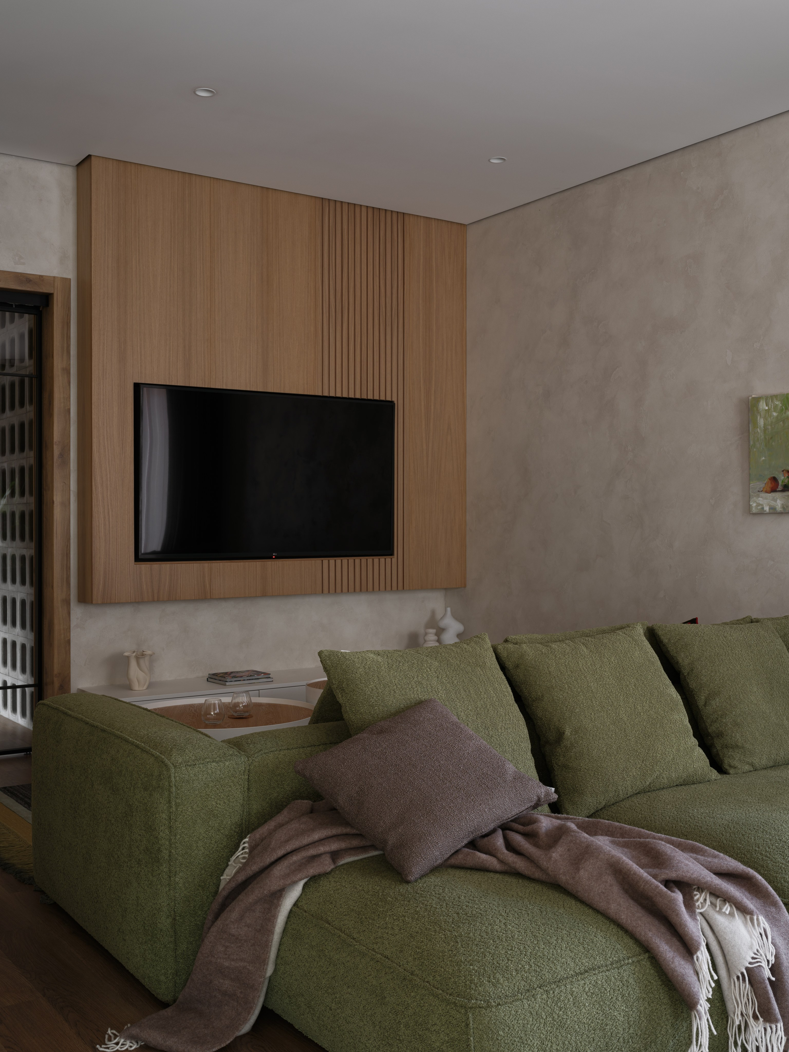 Гостиная с уютным зелёным диваном и деревянной панелью для ТВ-зоны. Атмосферный интерьер от Наталии Шелепниковой, запечатлённый фотографом Сергеем Денисенко и стилизованный Алёной Бершацкой, подчеркивает баланс уюта и современного минимализма.