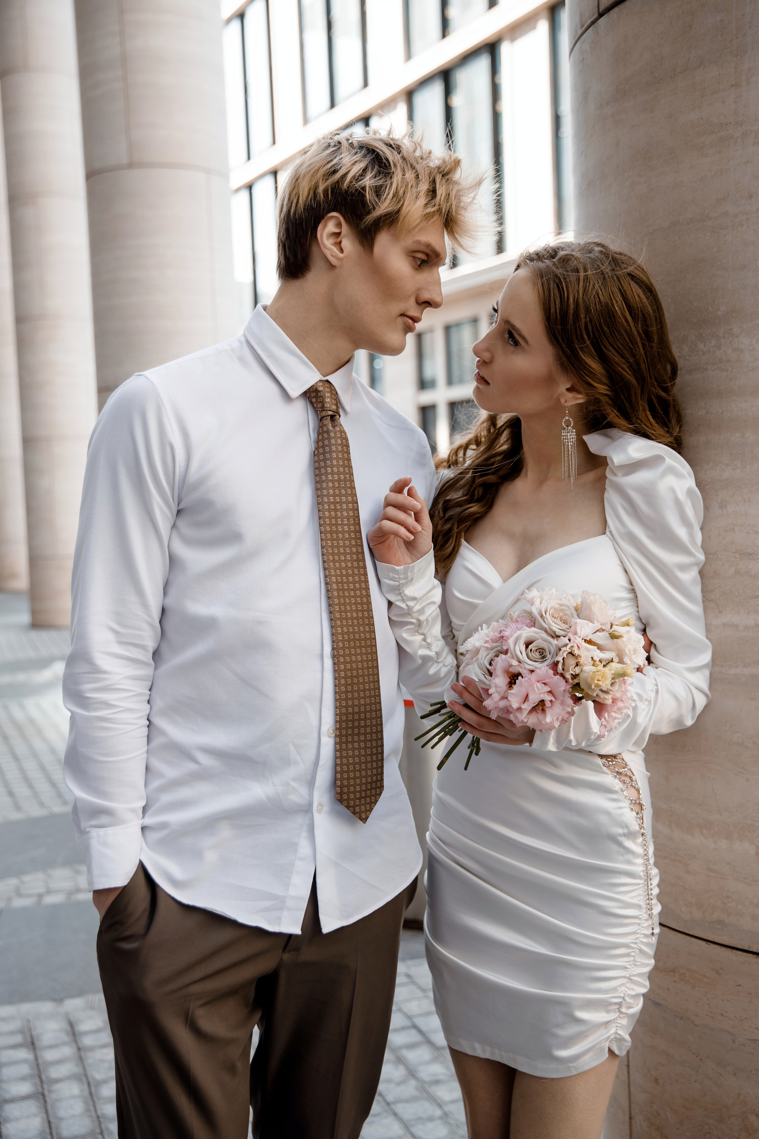 Невеста смотрит на будущего мужа, в руках у неё красивый букет