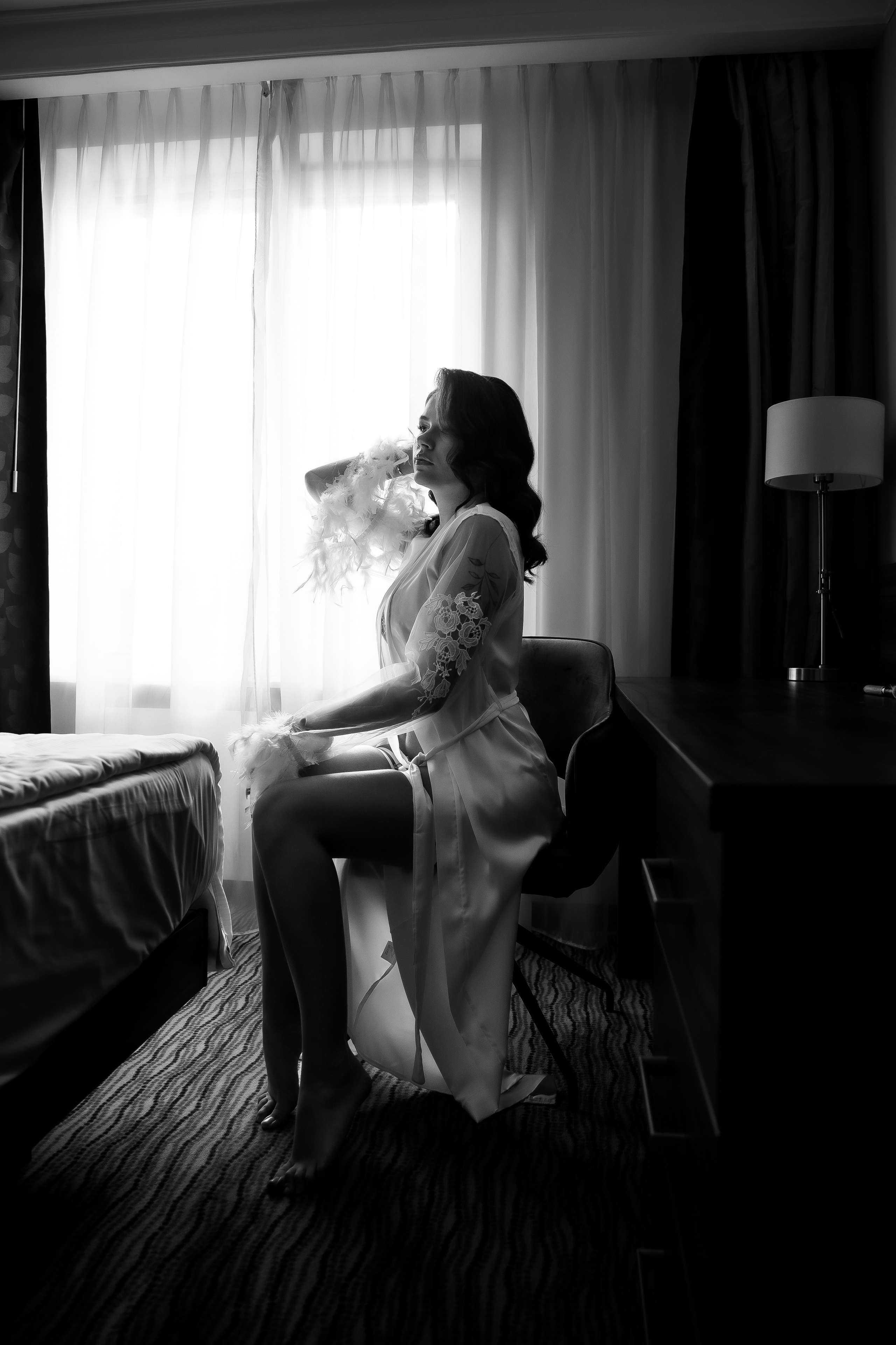 Красивое черно-белое фото невесты у окна в гостинице 