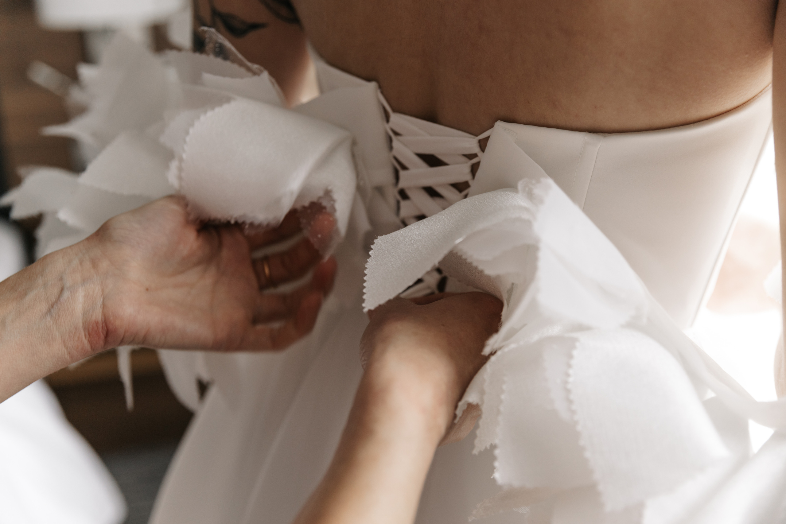 мама шнурует свадебное платье невесте 