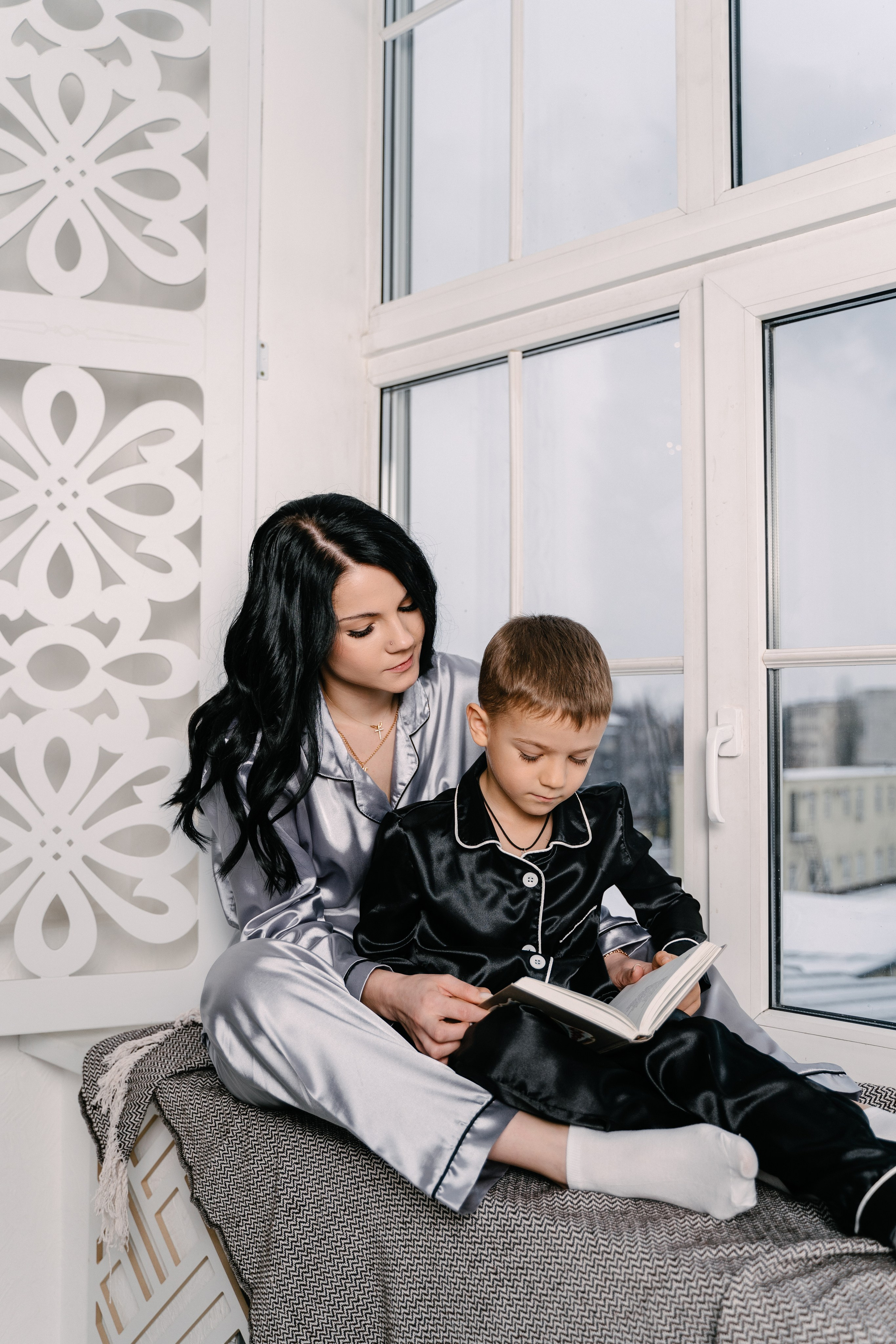 мама с сыном читать книгу у окна в пижамах на теплом пледе 