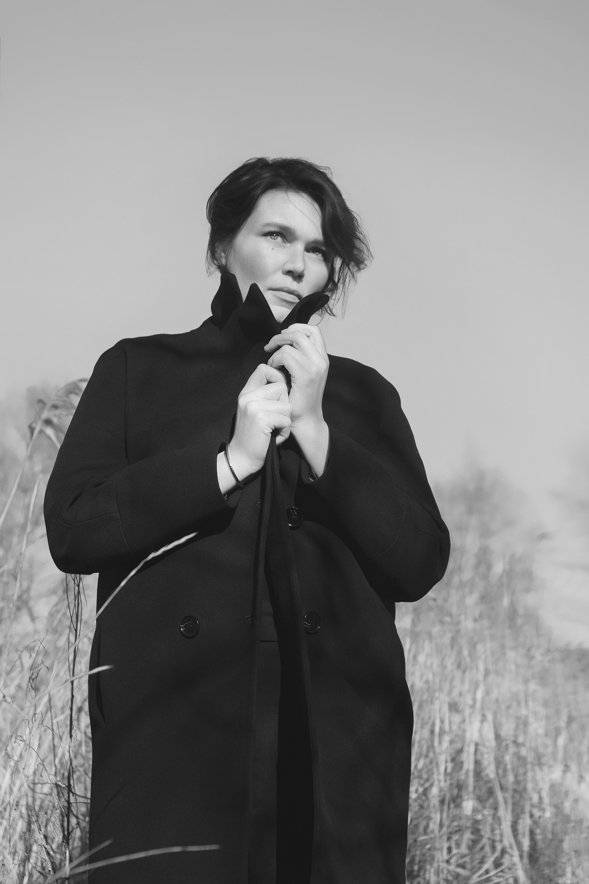 Минимализм, черно-белая фотография. Фотосессия на природе. Девушка в черном пальто. 