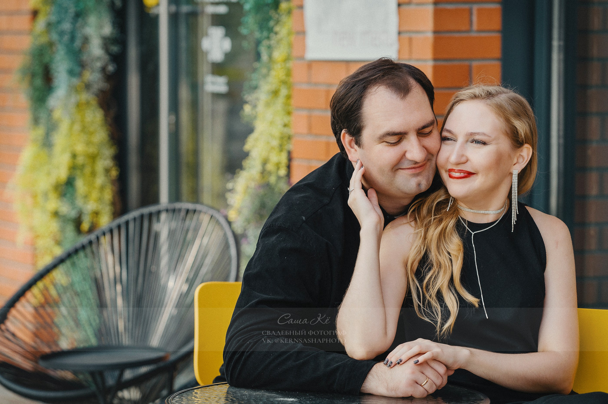 Пара сидит на скамейке в парке, обнявшись