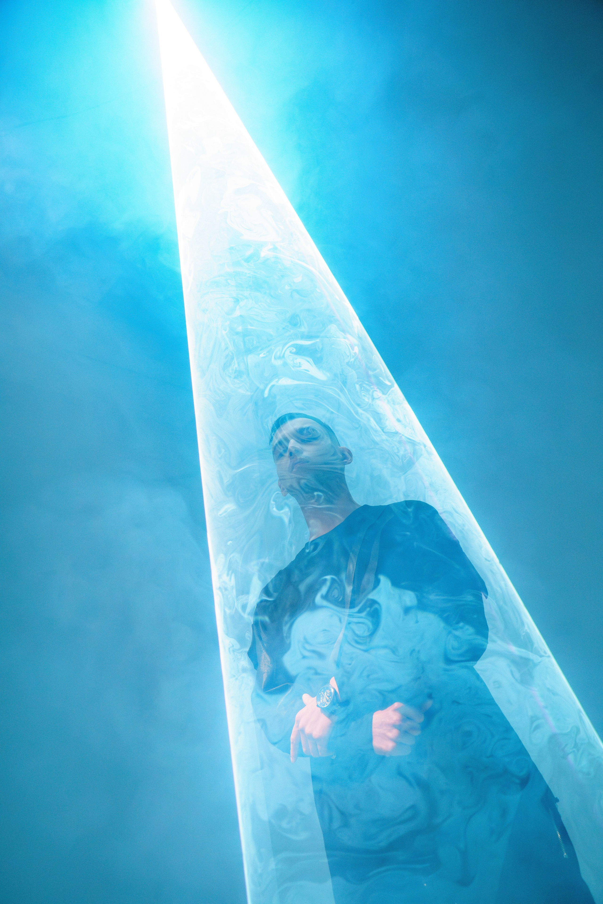 Мужчина стоит в плотном лазерном конусе света