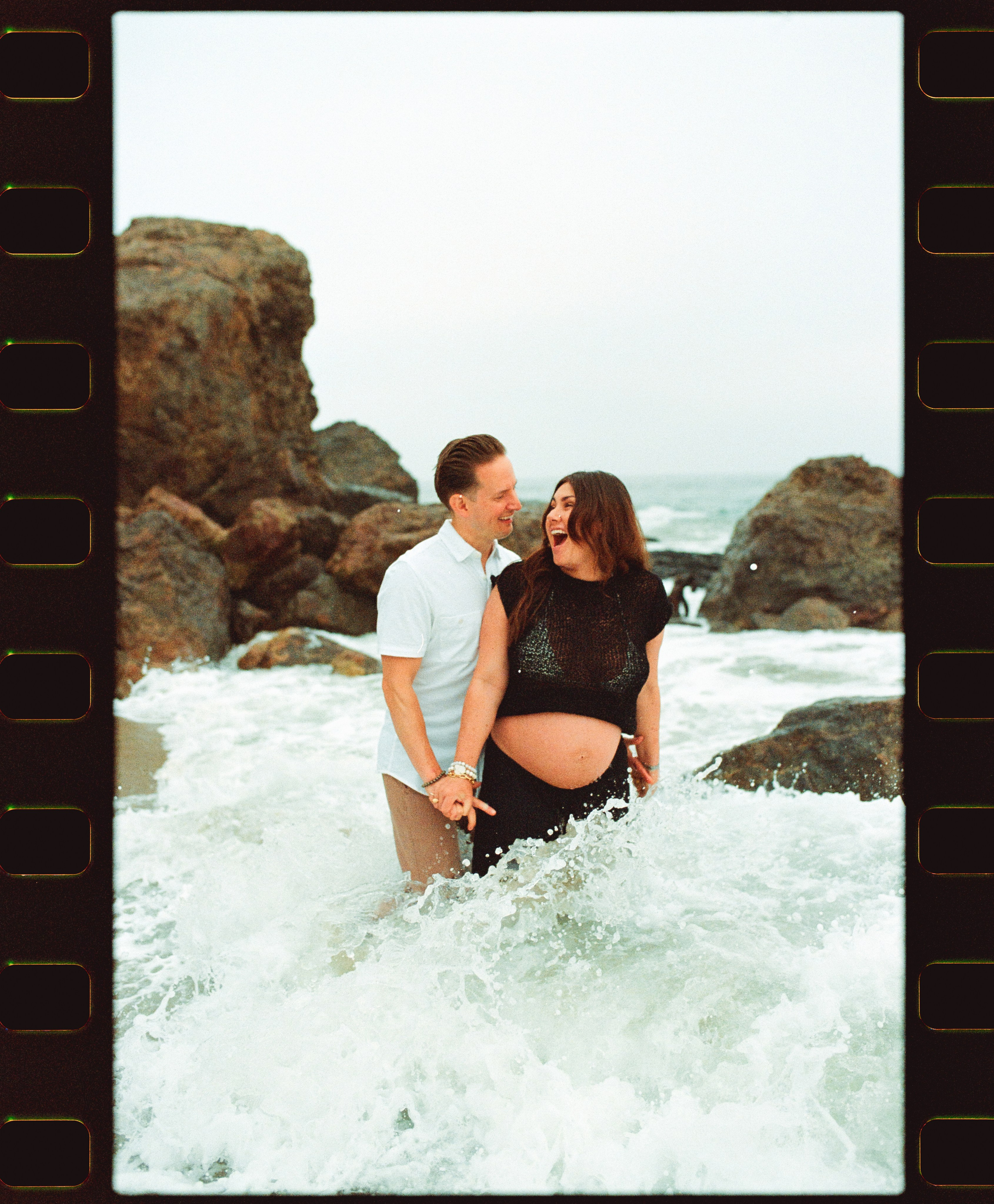 brave couple going into the ocean and waves crashing them