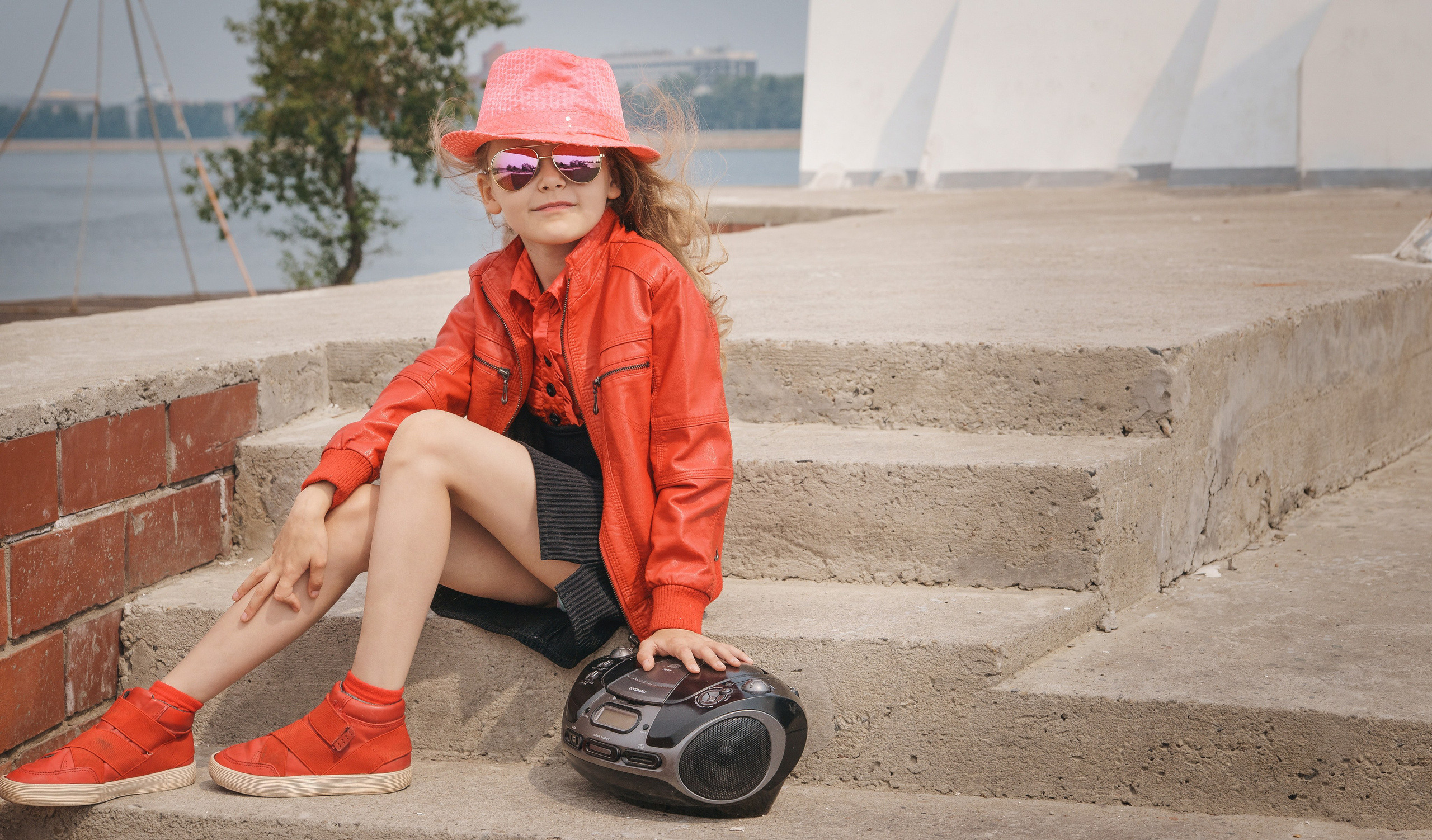 Детская фотосессия летом - девочка сидя с магнитофоном
