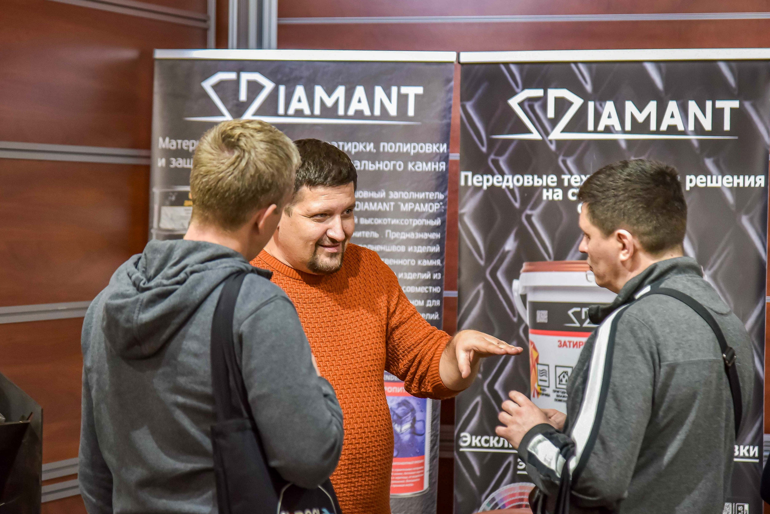Репортажная съемка с выставки в Москве: снимок передаёт атмосферу общения между представителем компании и посетителями выставки.
