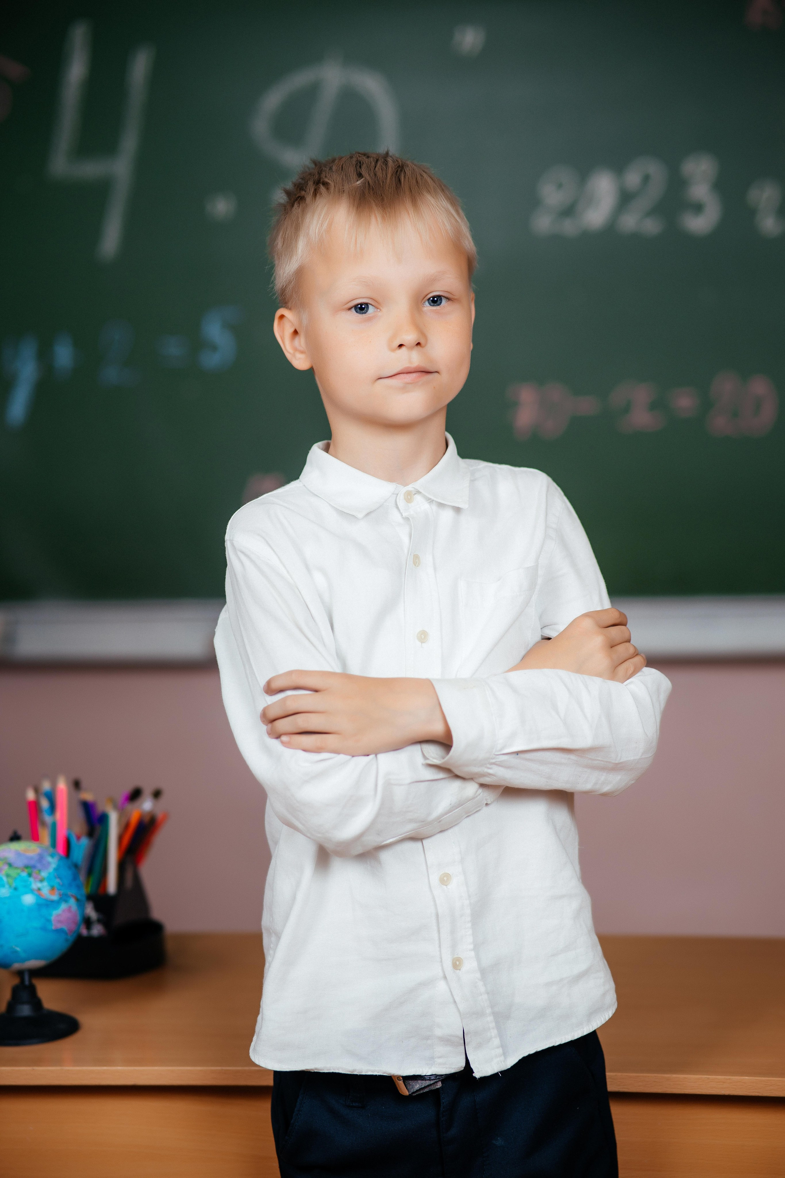 Выпускник позирует для виньетки в г. Усть-Каменогорск с на фоне школьной доски