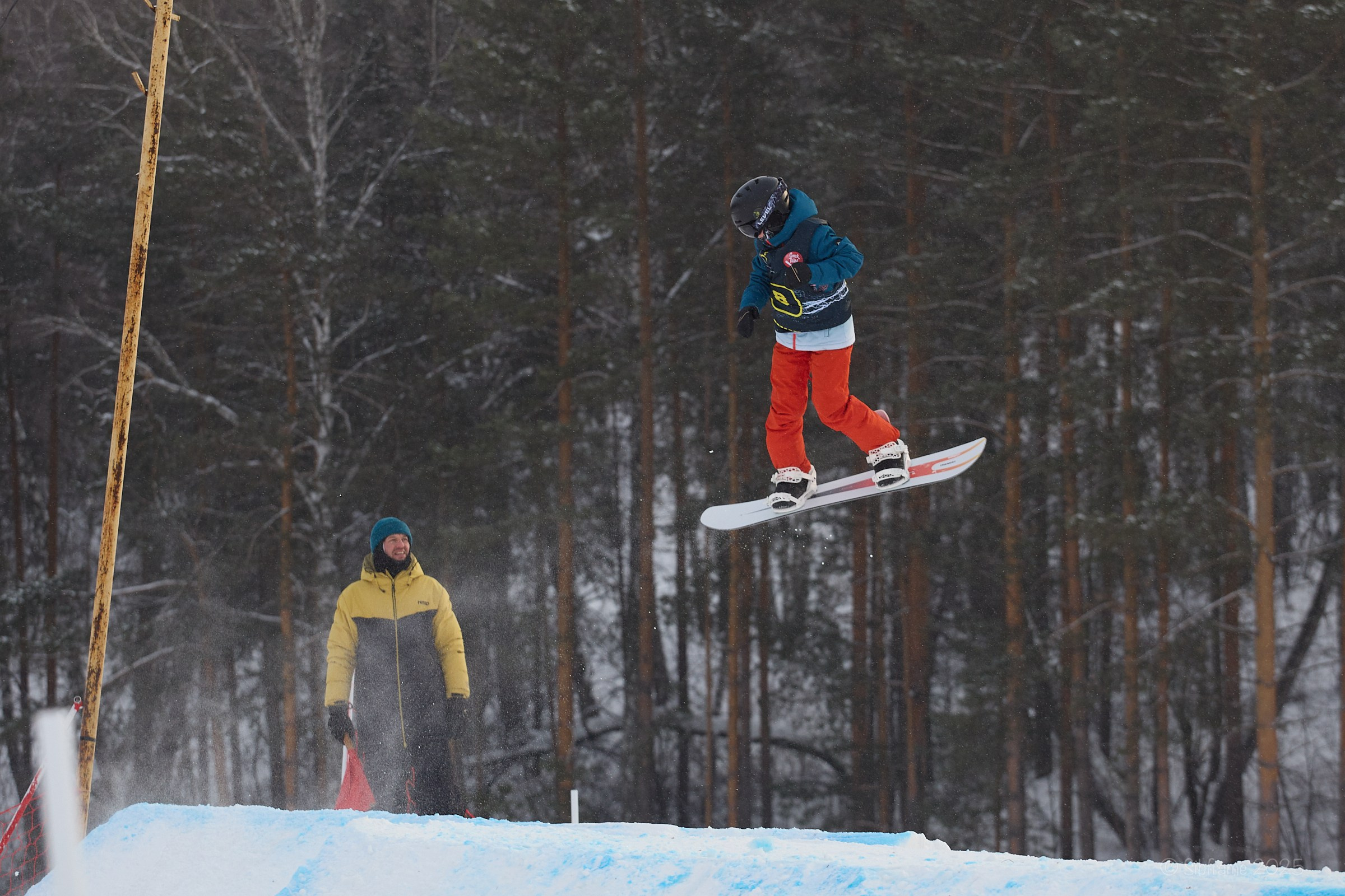 Прыжок сноубордиста под присмотром тренера