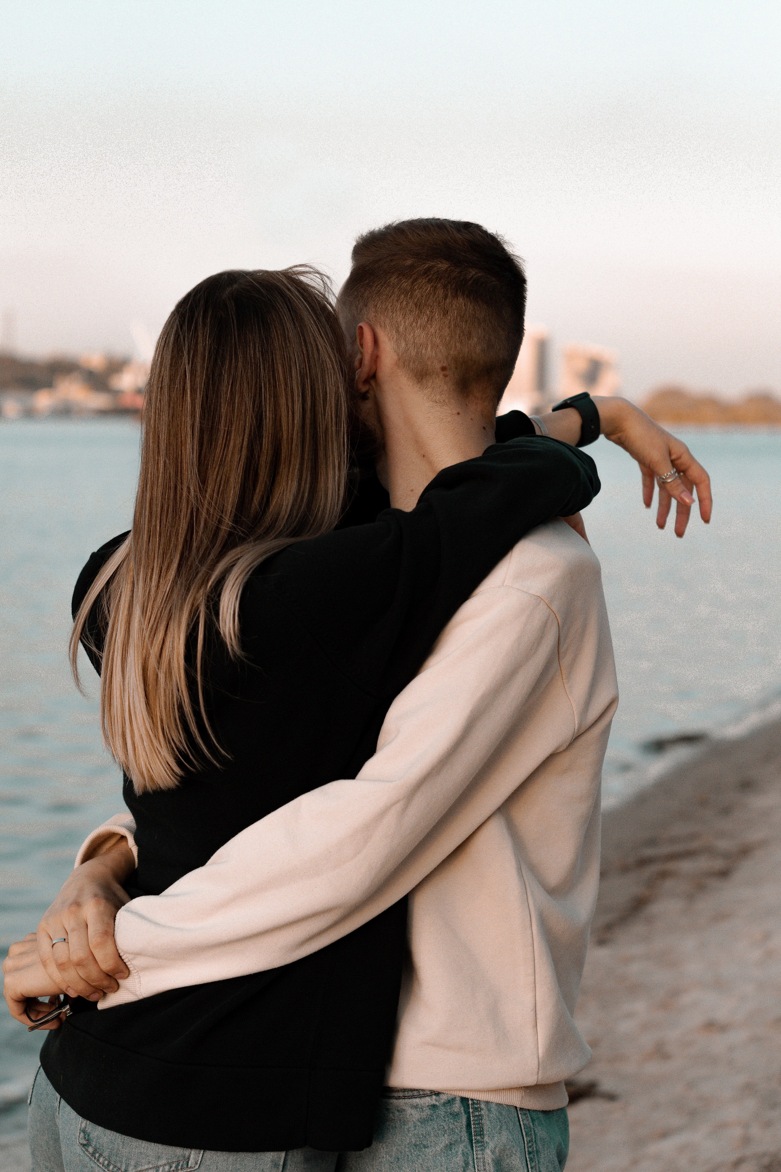 Парень с девушкой обнимаются и смотрят вдаль.