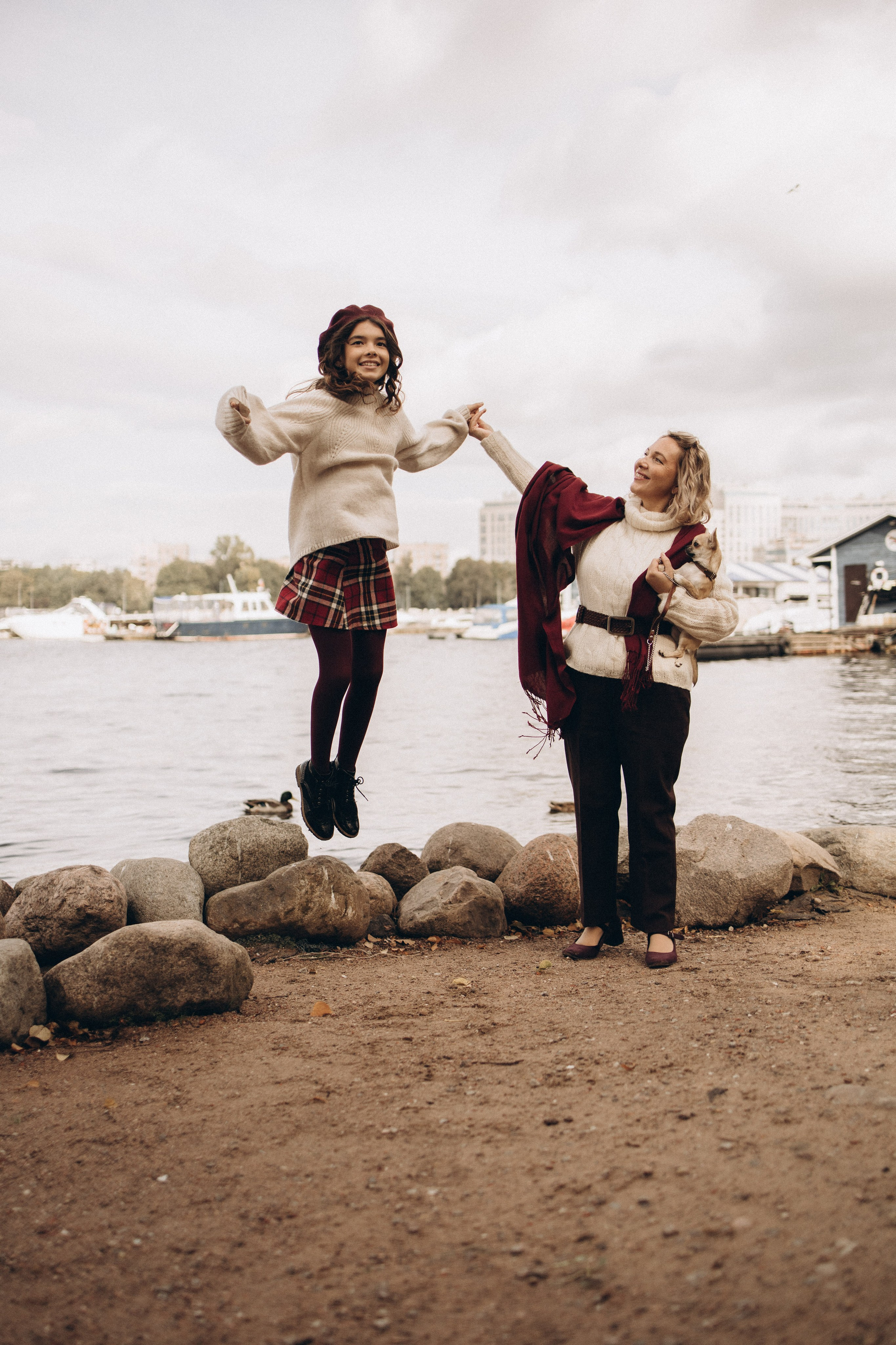 девочка держит маму за руку и весело прыгает