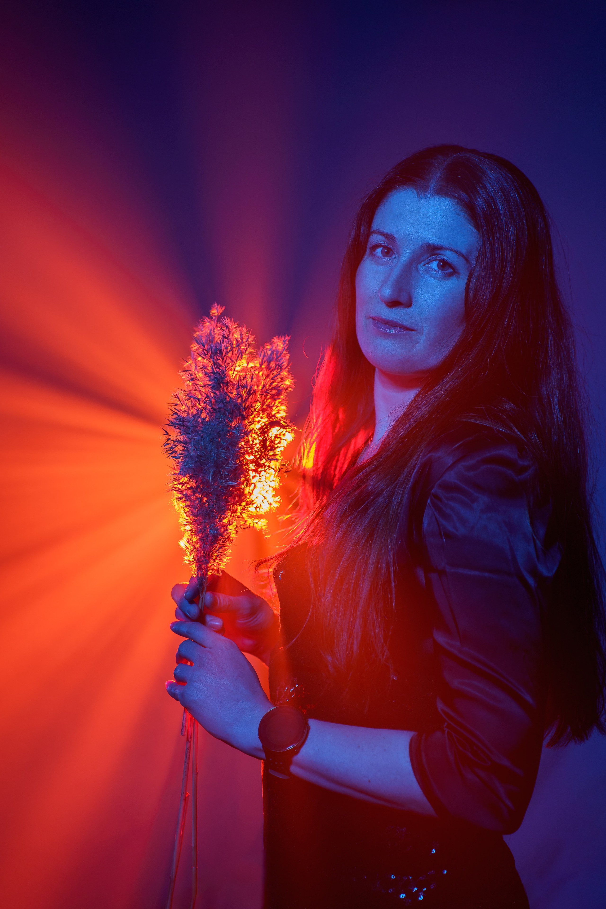 Портрет девушки с растением в красном и синем свете
